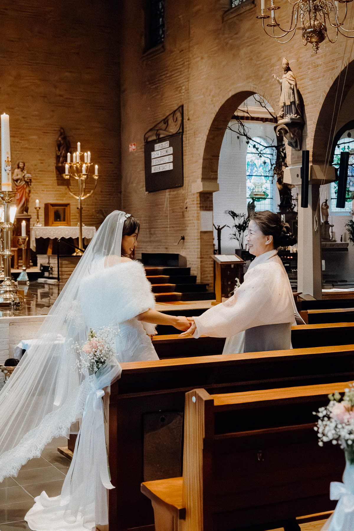 Bride and her mother-in-law, smiling at each other.