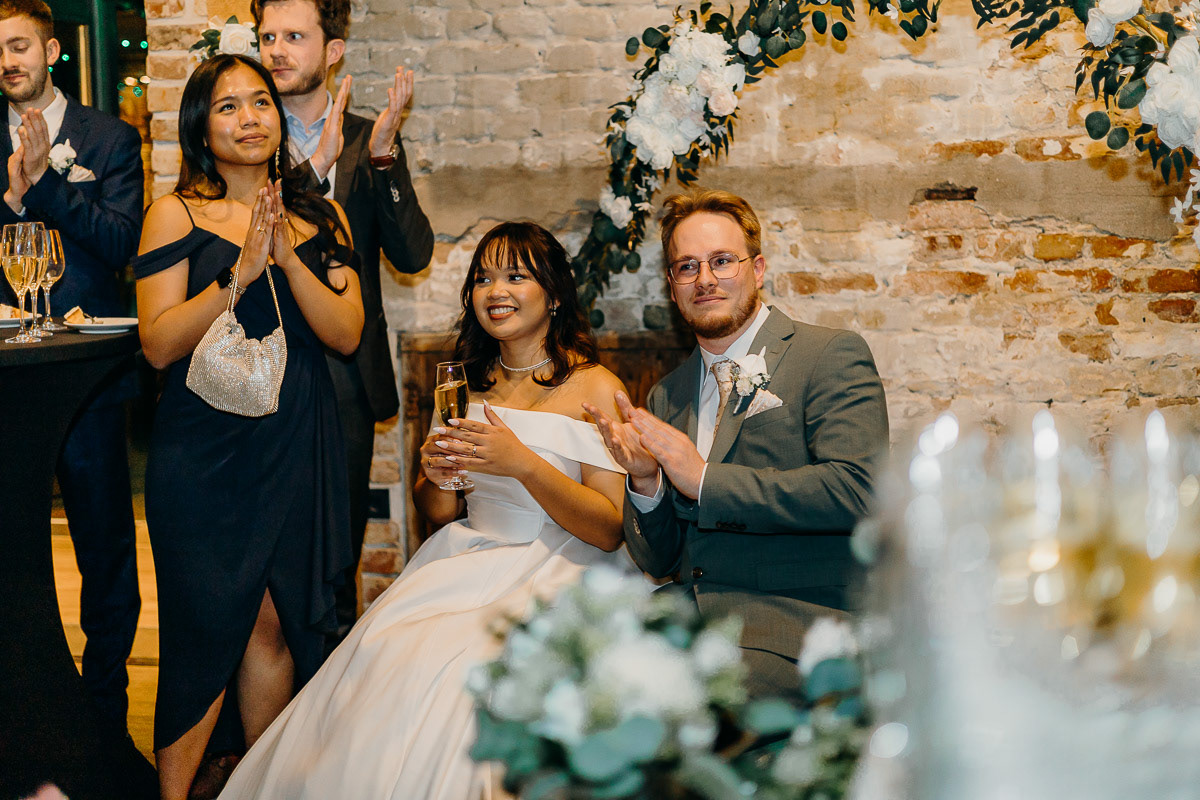 Bride and groom clapping after a special video.