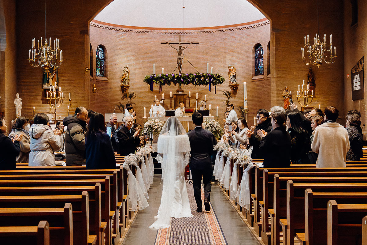 Bride and groom walking in, with the audience clapping to welcome them.
