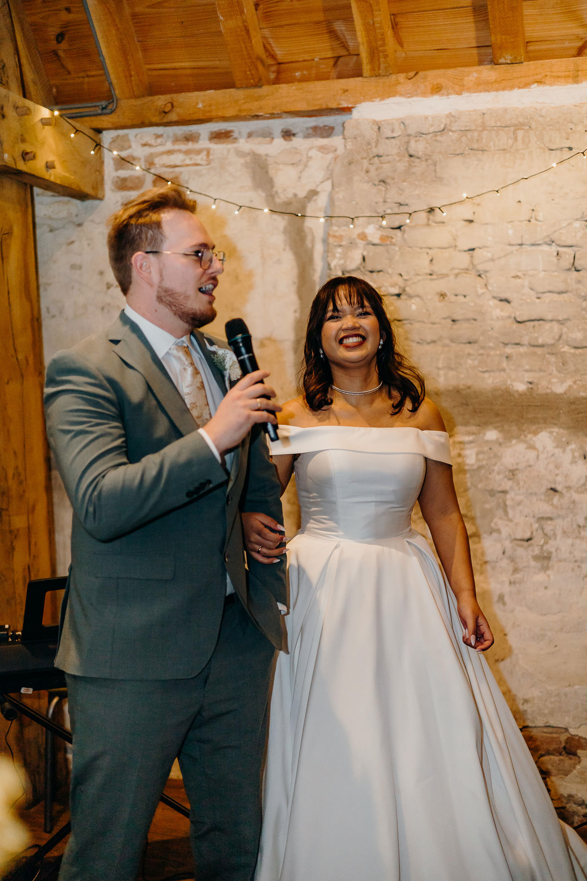 Speech from the groom, with the bride smiling widely, taken by wedding photographer in the Netherlands.