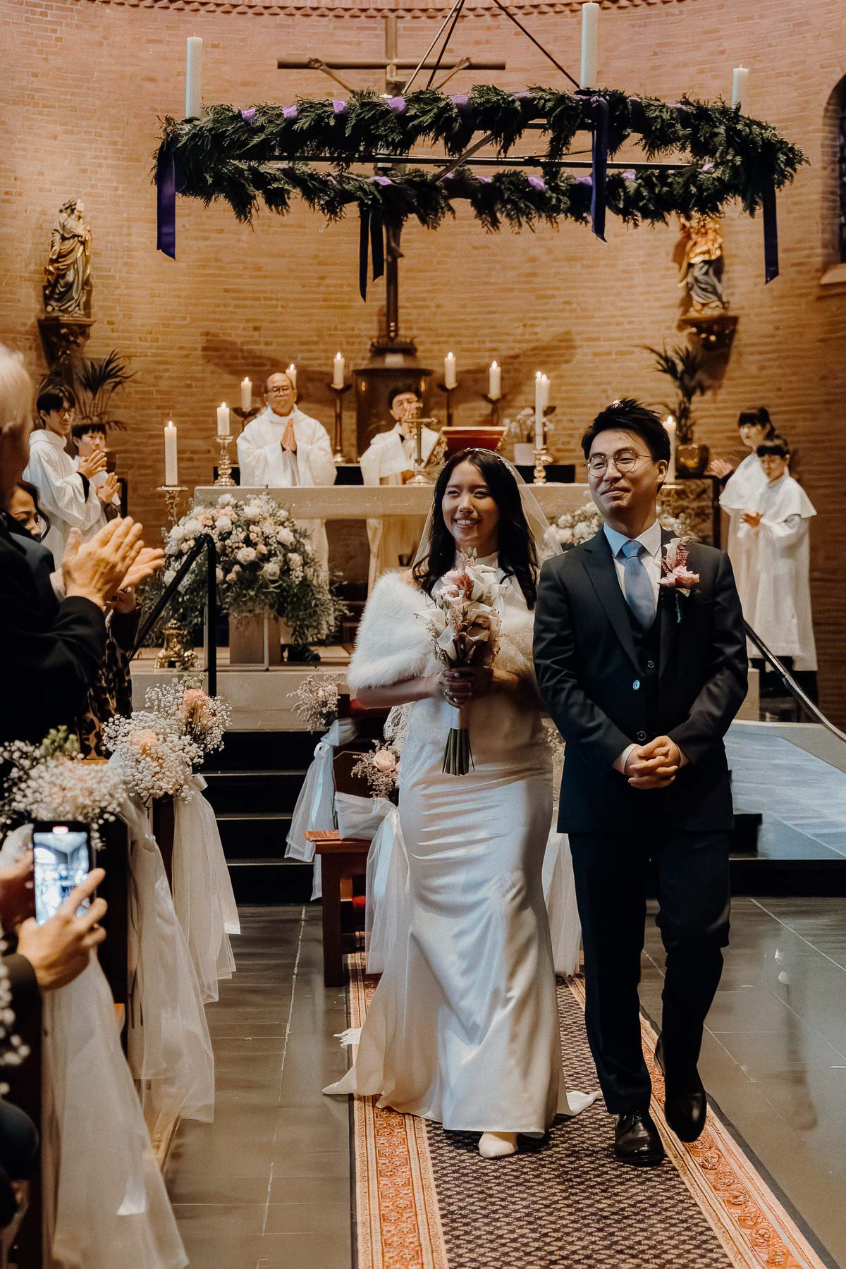 A wedding photograph of an Asian couple walking out of the ceremony, taken by an Amsterdam wedding photographer.