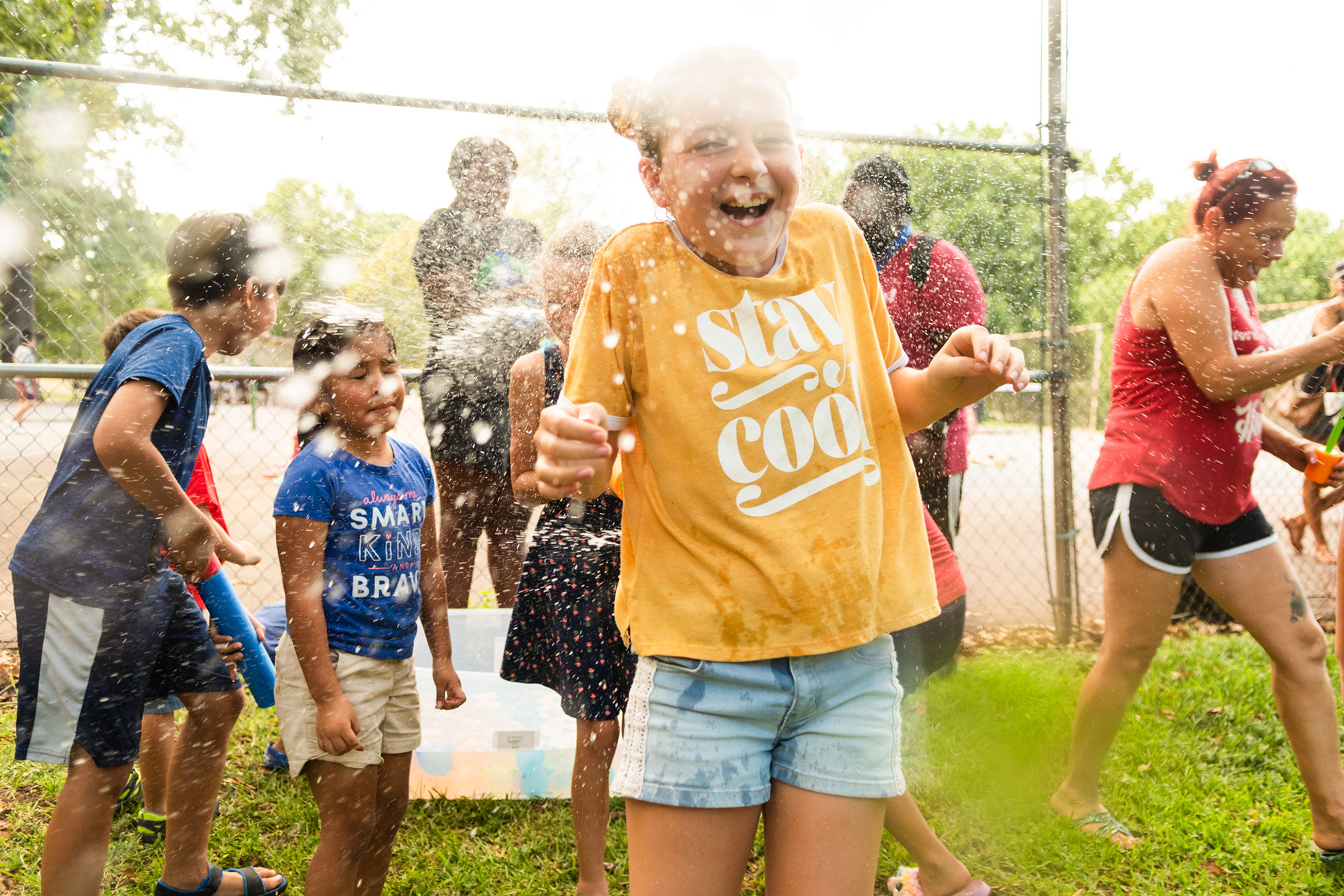 Ten-year-old Briley Schrader, in yellow, reacts with a smile as her cousin Taylor Stitt, 9, sprays her with water during Family Fun Night Thursday, Aug. 8, 2019, at Bergfield Park in Tyler. (Cara Campbell/Tyler Morning Telegraph)