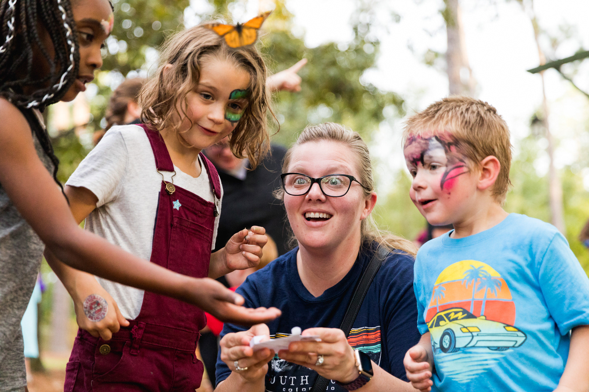 Attendees react in awe as a monarch butterfly takes flight before their eyes during the 2nd annual Butterfly Release Fundraiser hosted by Lufkin Community Partners Saturday evening, September 15, 2018, at The Angelina County Farmers Market in Lufkin, Texas. From the left are SaNia Henry and family members Mattie, Gretchen and Benjamin Tayloe. (Cara Campbell/The Lufkin Daily News)