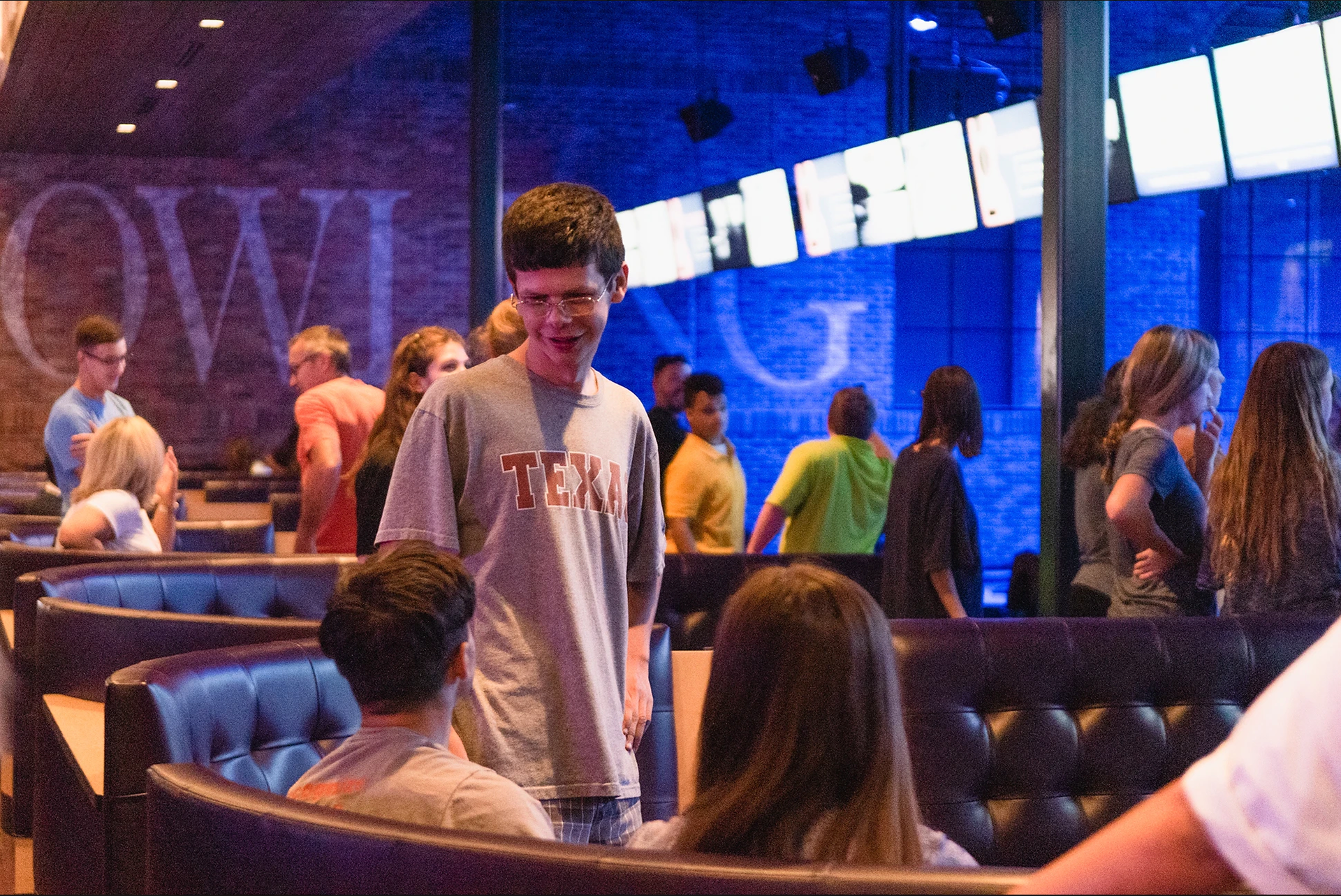 Robert E. Lee High School special education student Bret Lee, standing, talks with other attendees during Buddy Bowl Thursday at Time Square Grand Slam bowling alley in Tyler. (Cara Campbell/Tyler Morning Telegraph)