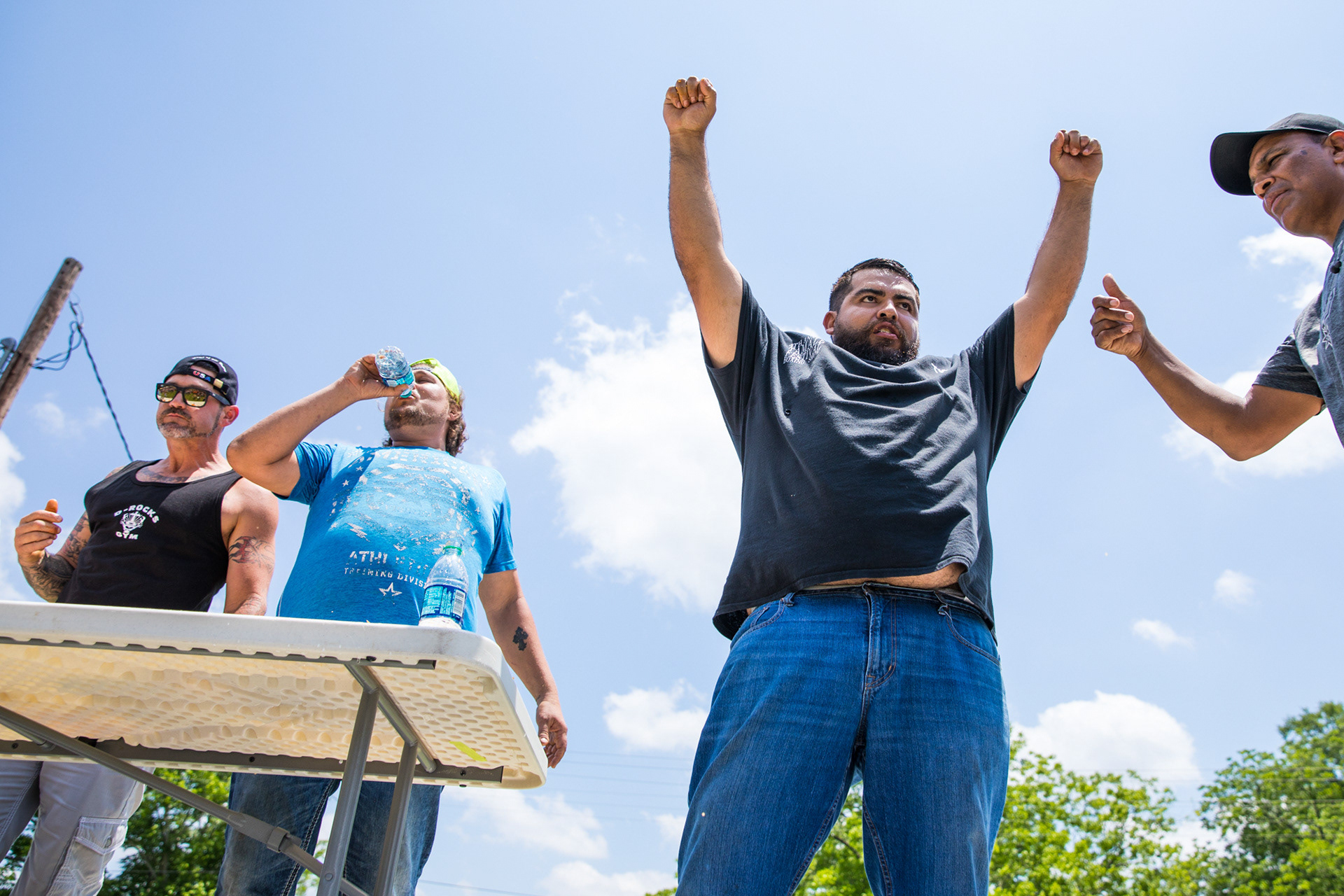 Mel Carrillo, second from the right, celebrates his first-place win in the tamale eating contest during the 11th annual Tamale Festival at Old Orchard Park Saturday afternoon, May 19, 2018, in Diboll, Texas. (Cara Campbell/The Lufkin Daily News)