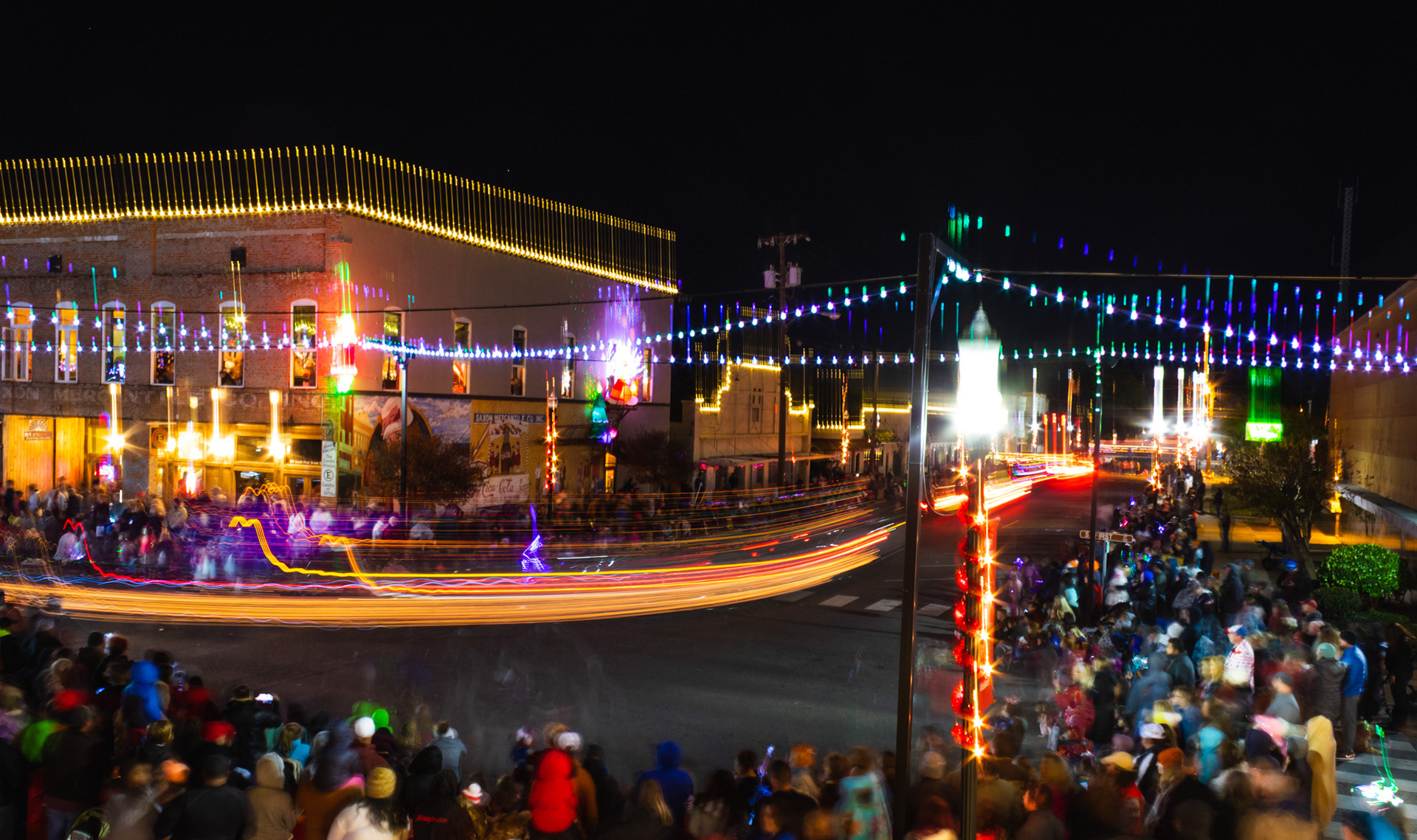 Lufkinites watch as multi-colored lights flow through downtown during the City of Lufkin Main Street Christmas Parade Monday night, November 26, 2018, in this long exposure image. (Cara Campbell/The Lufkin Daily News)