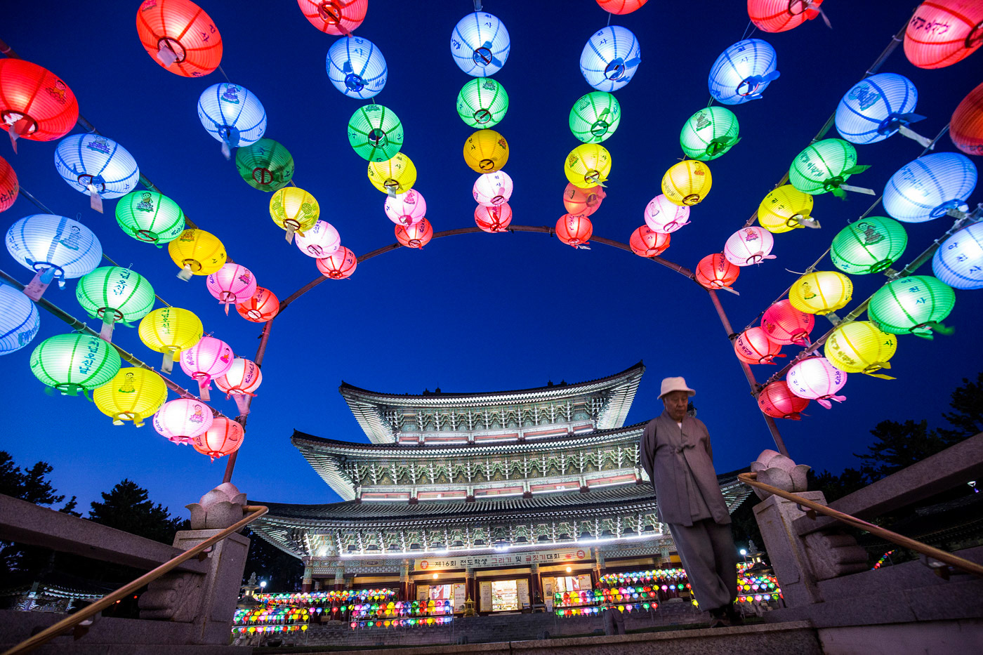 DAEPO, Seogwipo, Rep. of Korea -- Yakcheon temple is surrounded with lanterns celebrating the Buddha's birthday as a monk walks towards a staircase leading away, in Daepo, Korea, on April 28, 2017.