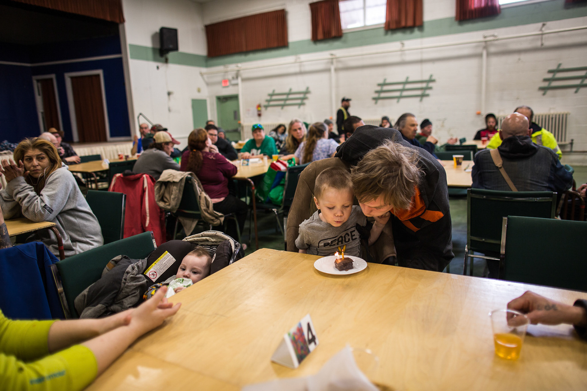 BRANTFORD, Ont.--March 24, 2019 - Justin Riley helps his son, Elijah Riley-Miller blow out a candle on a slice of cake. Elijah celebrated his birthday in part with a hot meal from the Syndenham Sunday Supper Club at Sydenham St. United Church