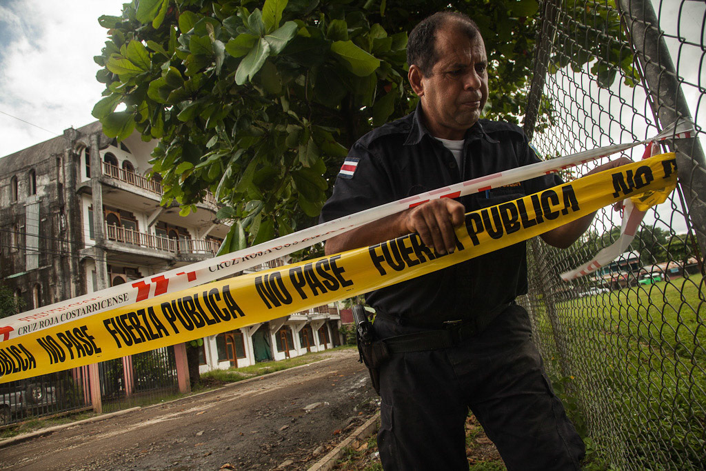 NOSARA, Costa Rica - (06/09/2012) : Nosara public force chief Gerardo Aguilar ties warning tape to block of a street where the town's largest, and code-breaking building stands at risk of collapse due to damage sustained during the earthquake which struck the pacific coast of Costa Rica. An earthquake of 7.6 on the Richter scale struck in the early morning hours of September 5th, 2012 near the city of Nosara, at Cangrejal de Nicoya, damaging buildings up to 40km away from the epicentre, the quake was felt across the region.
