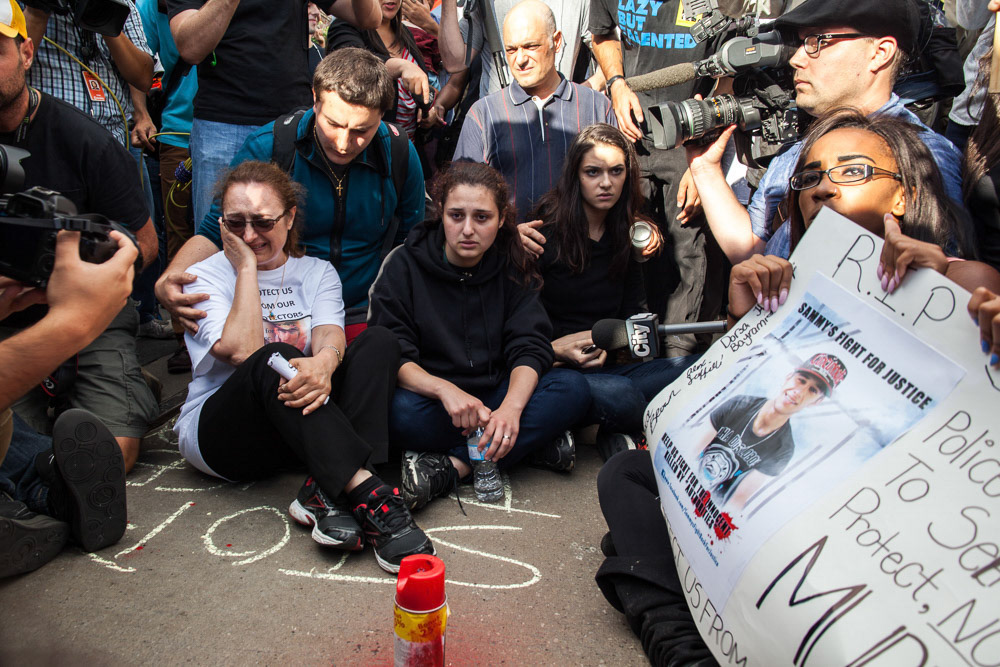 TORONTO, Ont. : (29 July 2013) - Sahar Bahari cries as she sits in front of the spot where her son was shot and killed by police on Friday July 26, 2013. Yatin was killed on a streetcar on Dundas West while allegedly holding a knife. Photo by Giordano Ciampini