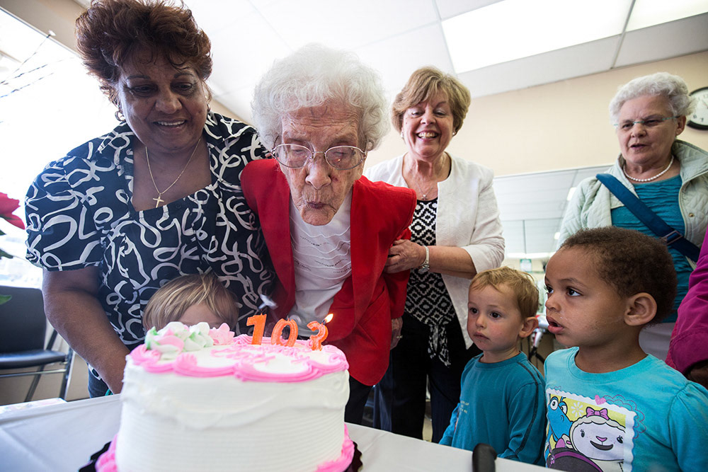 TORONTO, Ont. - 103-year old Edith Woodley blows out her birthday cake candles alongside Kam Babulal, salon owner Vicky Del Mastro and Bertha Sharpe with special little guests Jackson S. and Nia H. Staff and visitors of Vicky's Hair Style celebrated the 40-year patron with a cake and warm wishes on her 103rd birthday. Photo by Giordano Ciampini