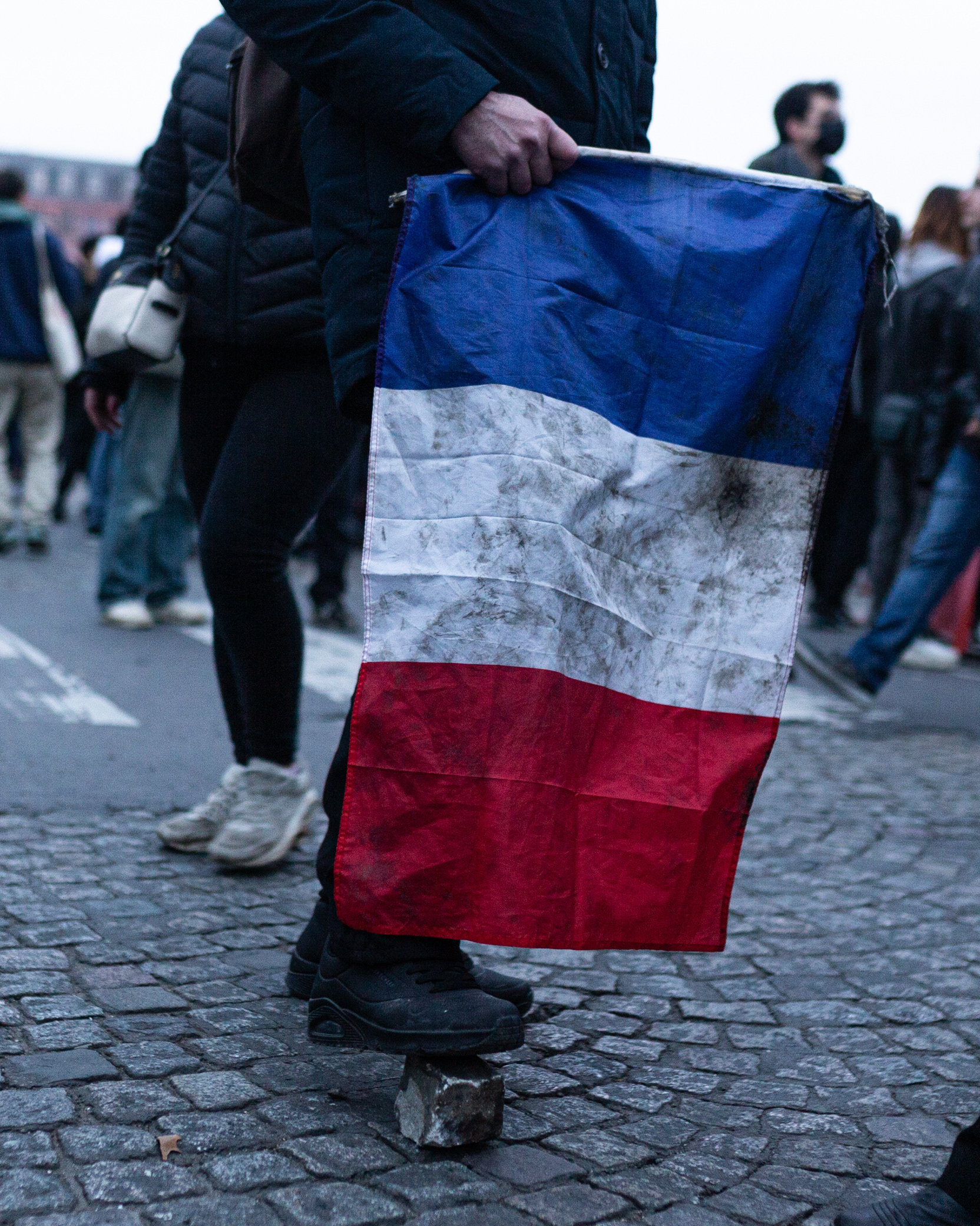 31.01.2023 Paris - A dirty France flag is seen during the demonstration against the new pension reform plan in Paris. A French pension reform strike took place for the second time this month where hundreds of thousands took the streets in Paris to pressure President Emmanuel Macron to drop the pension reform plan.