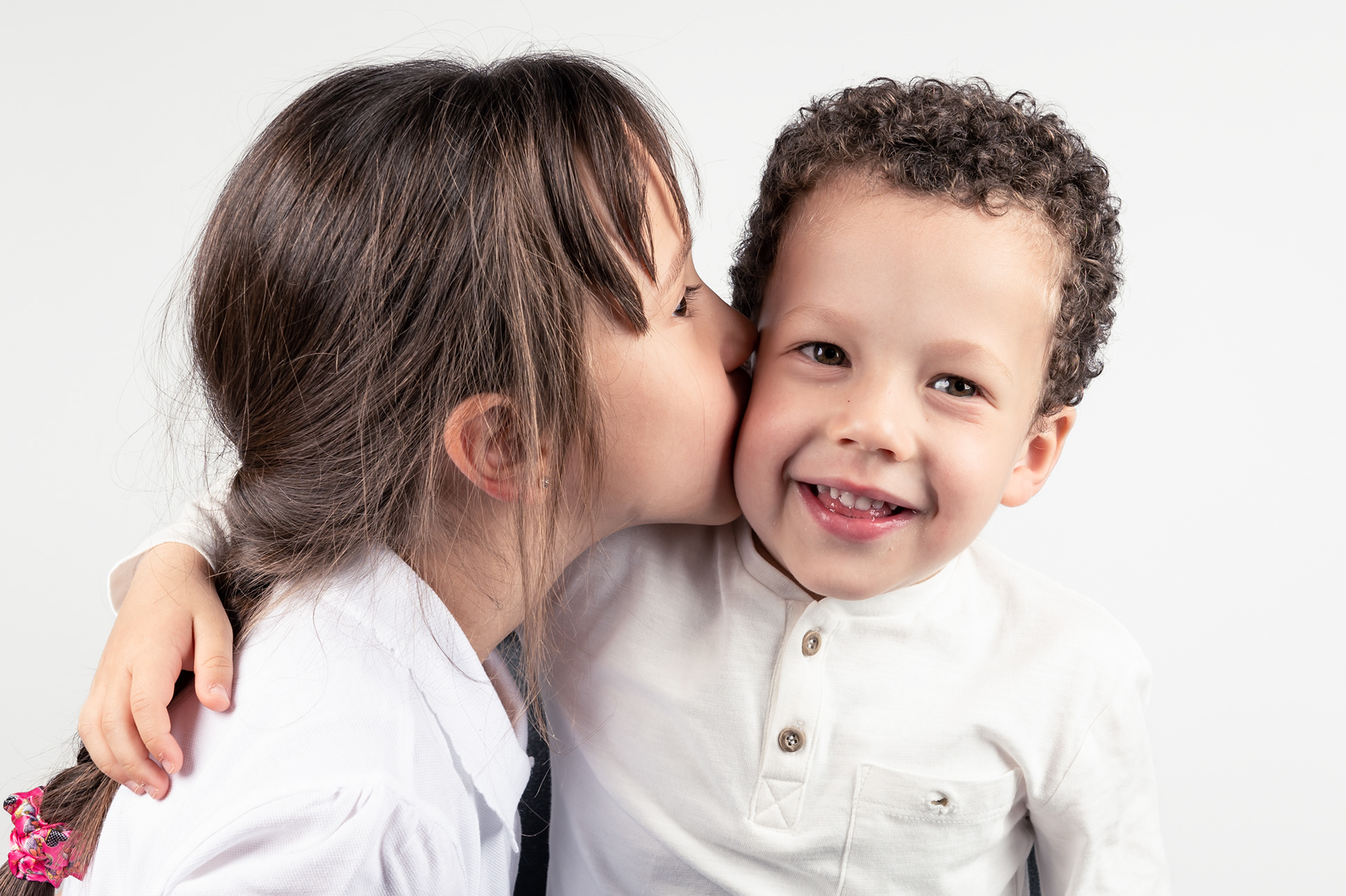 Brother and sister photoshoot in Bolton, Manchester, studio, white background, sister kissing young brother