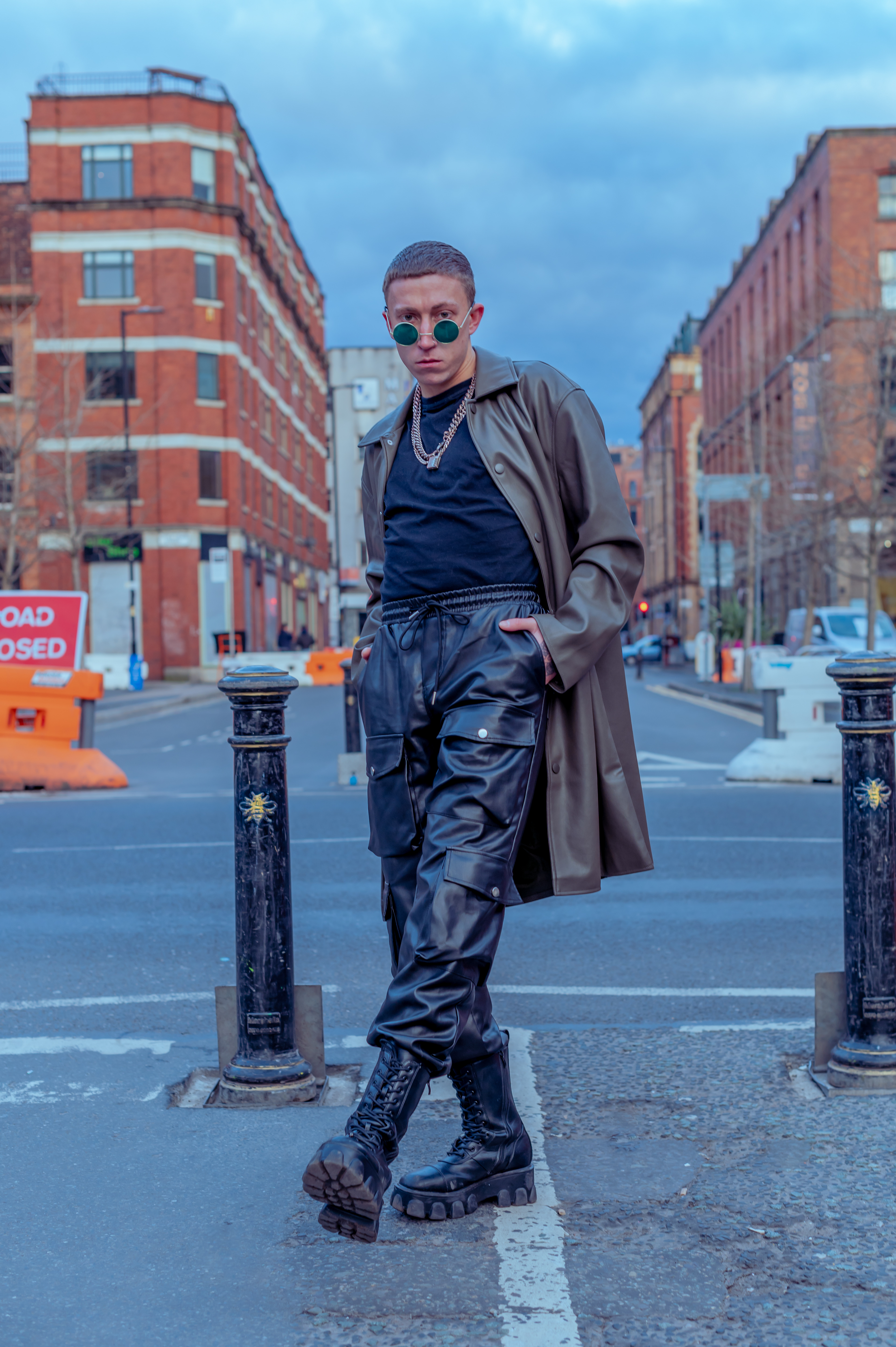Man in boots, long leather jacket, leather pants, black t-shirt and chains, in Manchester - Northern Quarter 