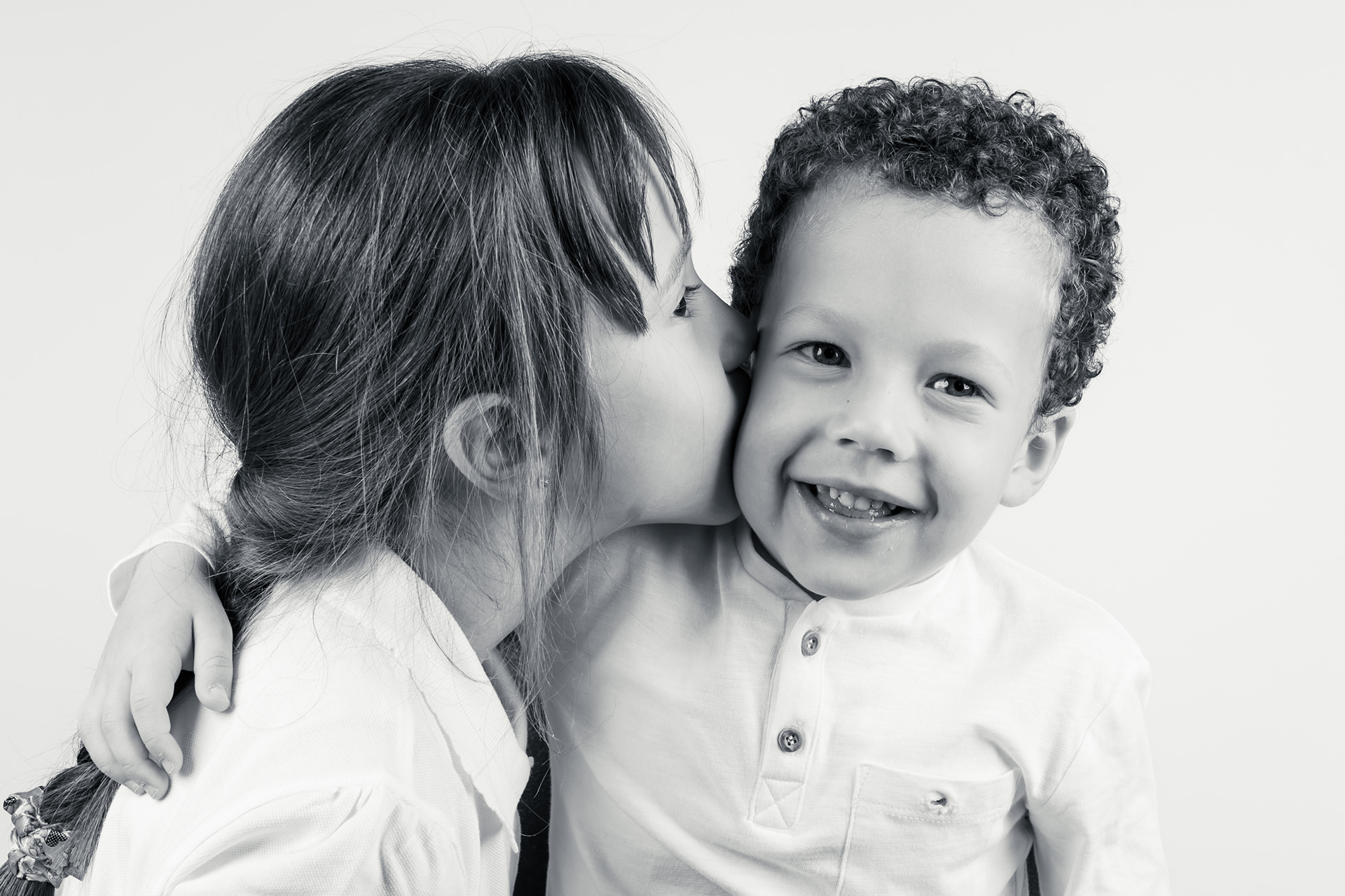Brother and sister photoshoot in Bolton, Manchester, studio, white background, sister kissing young brother