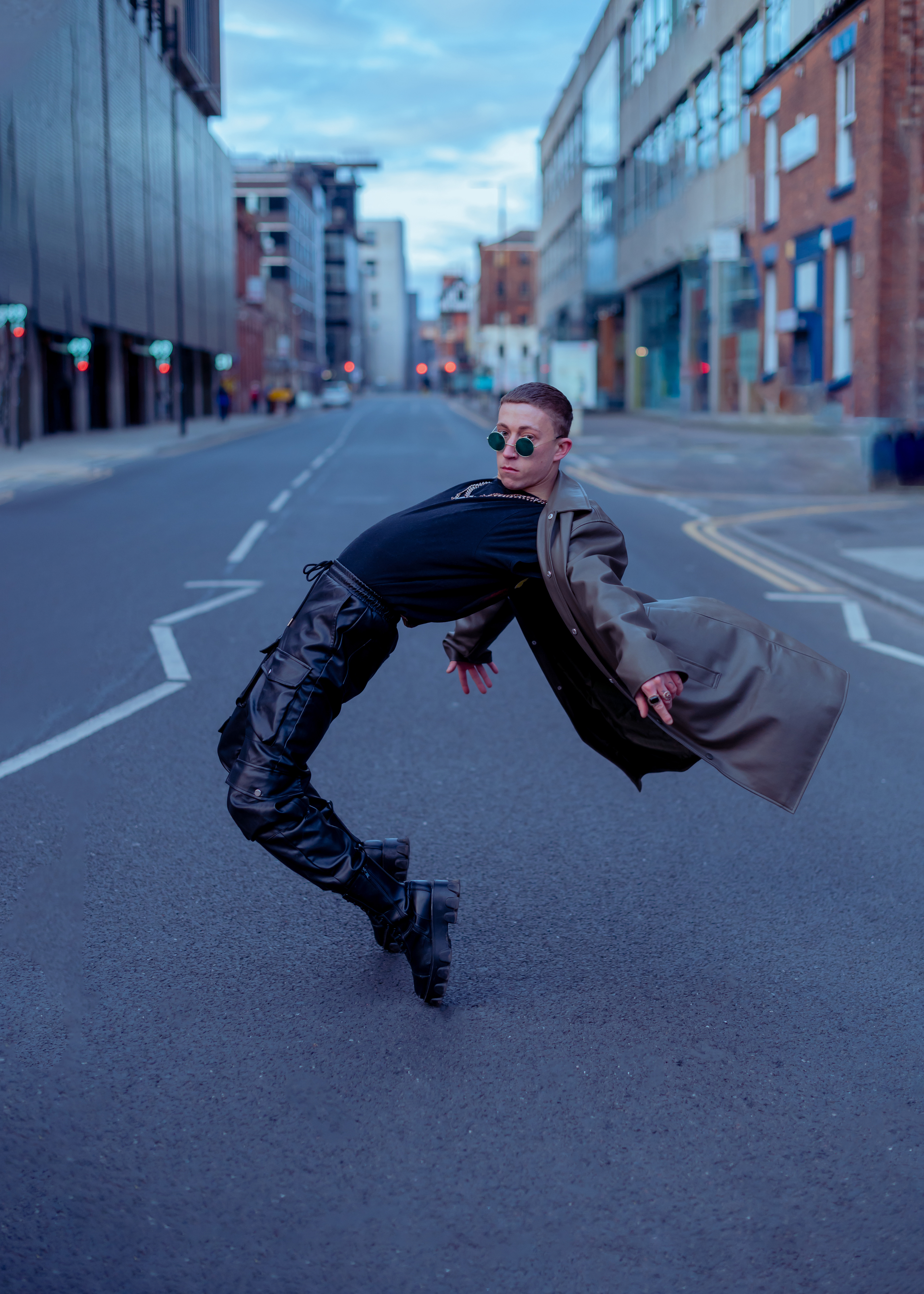 Man in boots, long leather jacket, leather pants, black t-shirt and chains, in Manchester - Northern Quarter 