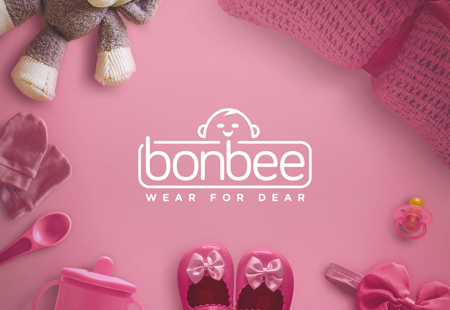 Bonbee Indian baby wear brand and package design: white logo on a pink flat lay of baby girl shoes and toys