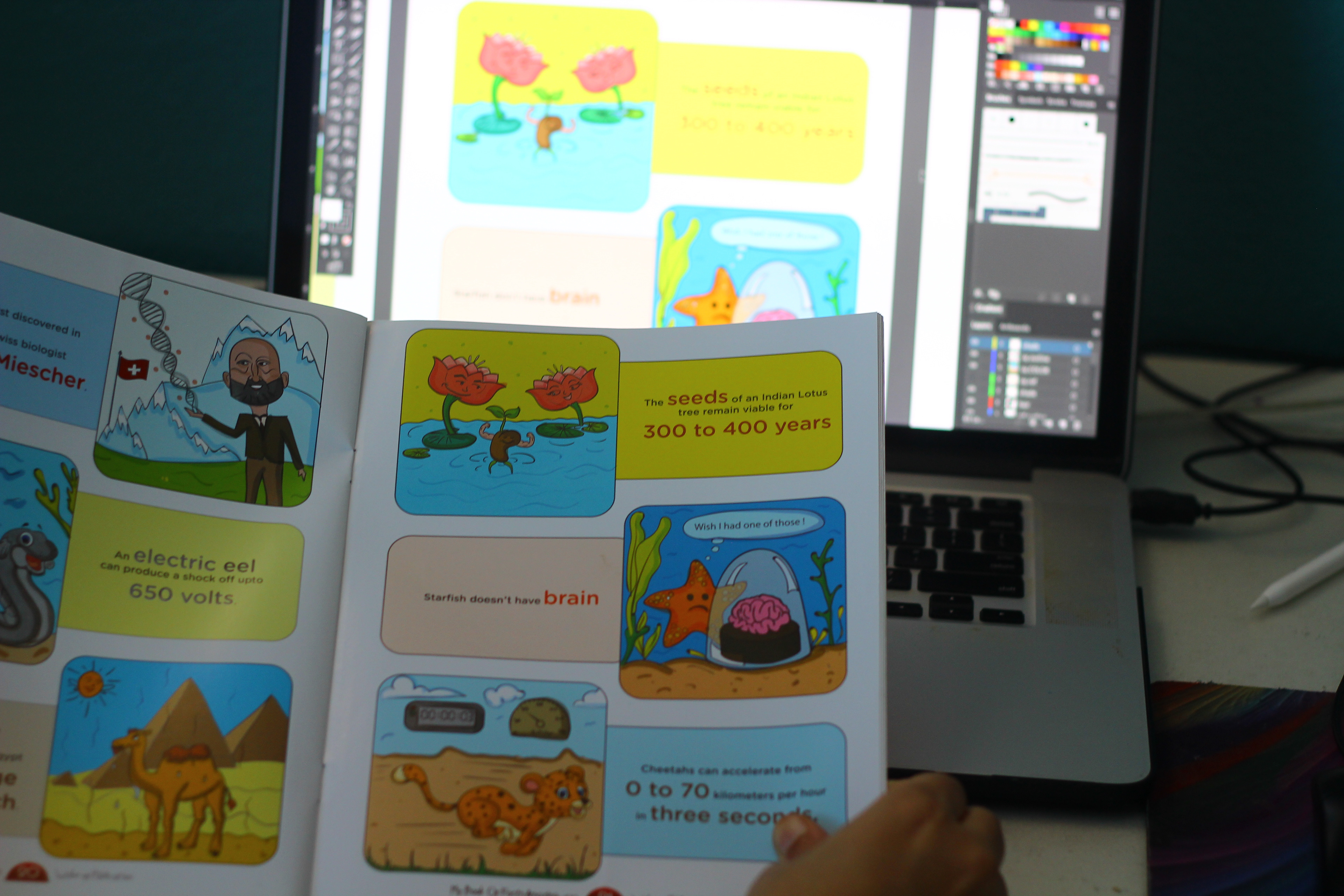 My Book of Facts, 100 amazing facts, pen to press: printed pages on a desk beside a computer