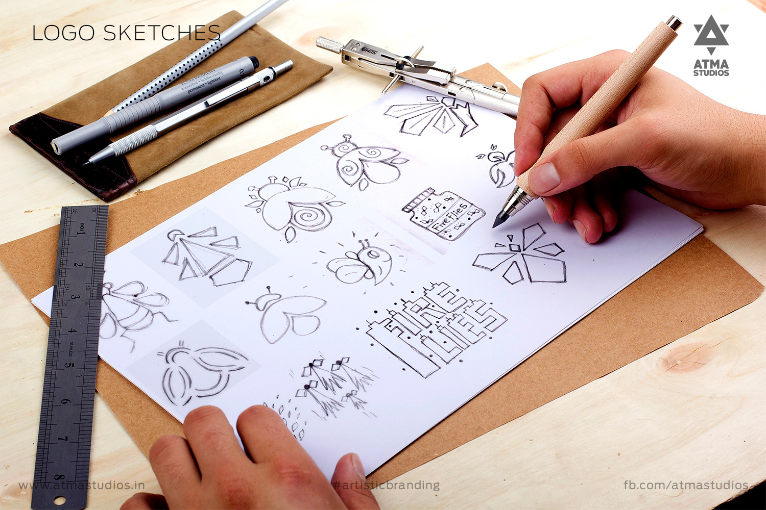 Hand sketching Fireflies logo concepts with a pencil on paper