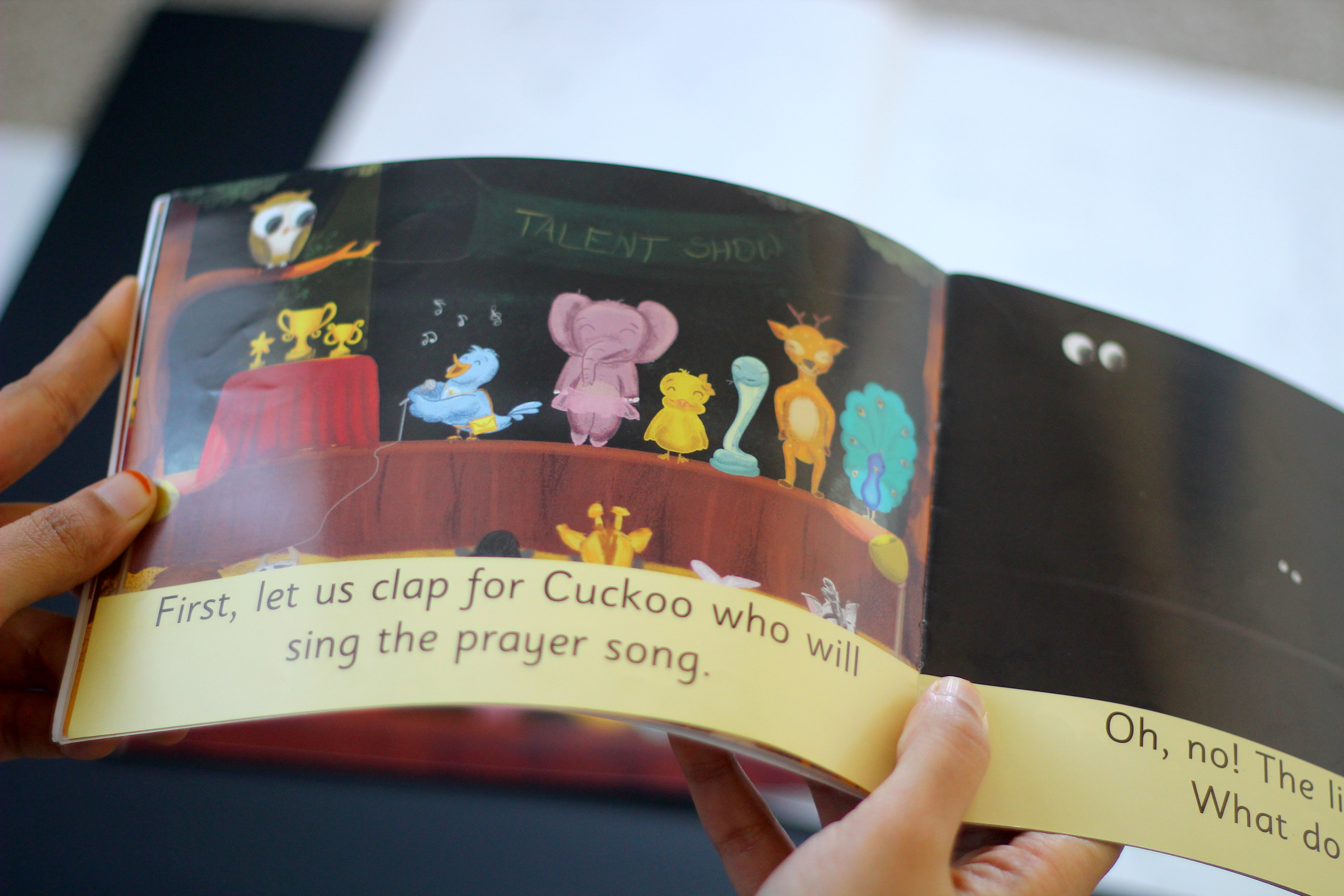 The Missing Prizes children's book: reader holding an open spread with animals singing