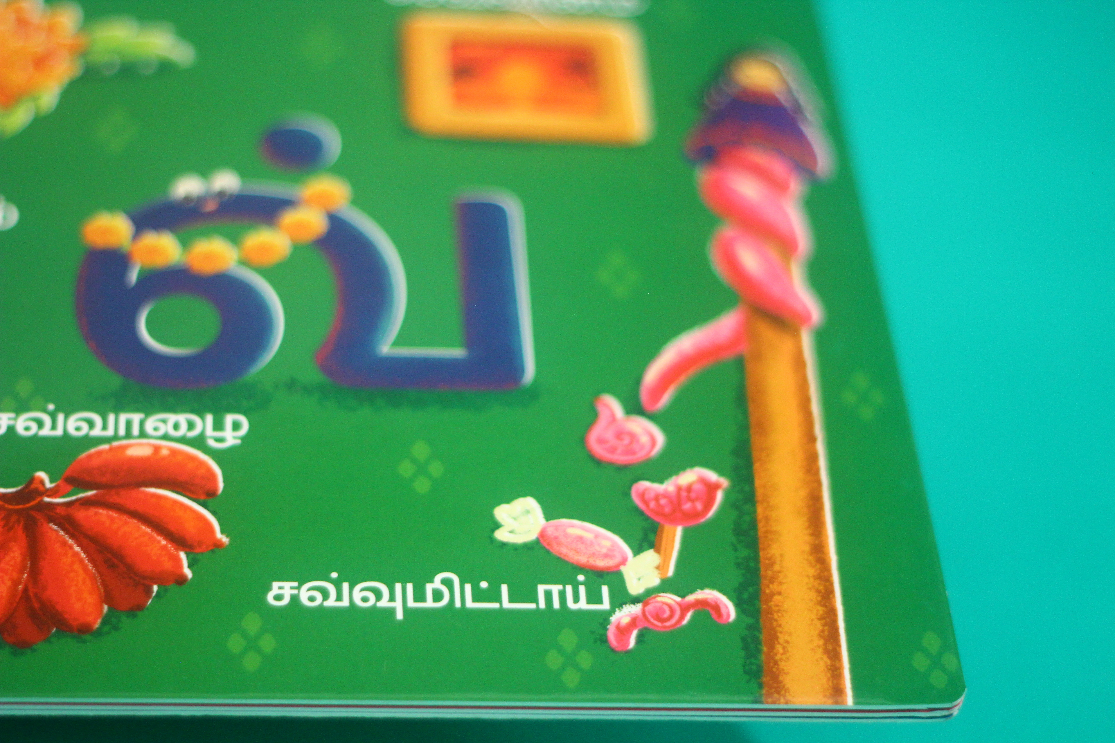 Vidhaippom Meithamizhai Tamil alphabet board book: green page with sweets for the letter pa