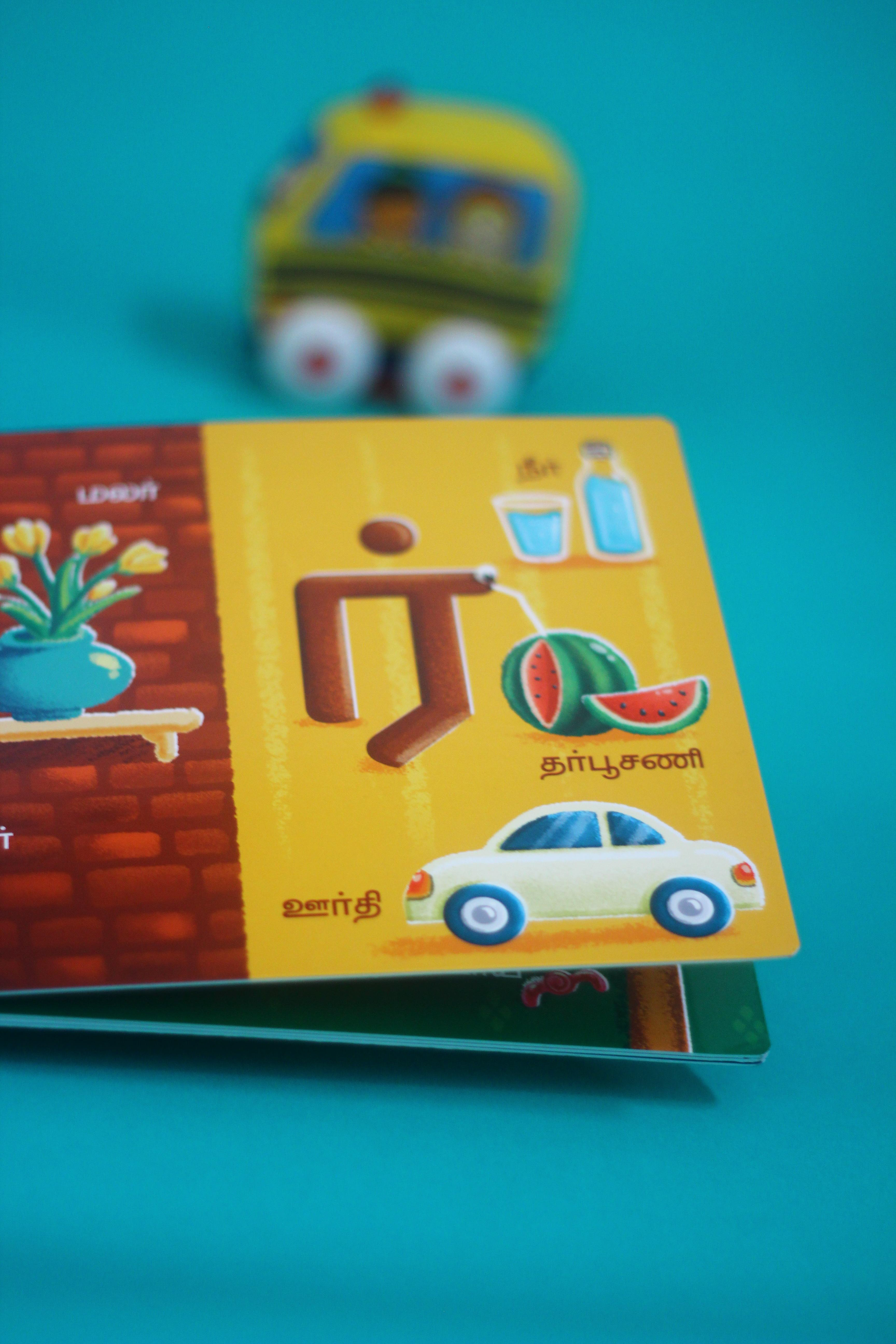 Vidhaippom Meithamizhai Tamil alphabet board book: page with a peacock, bus and car for the letter ra