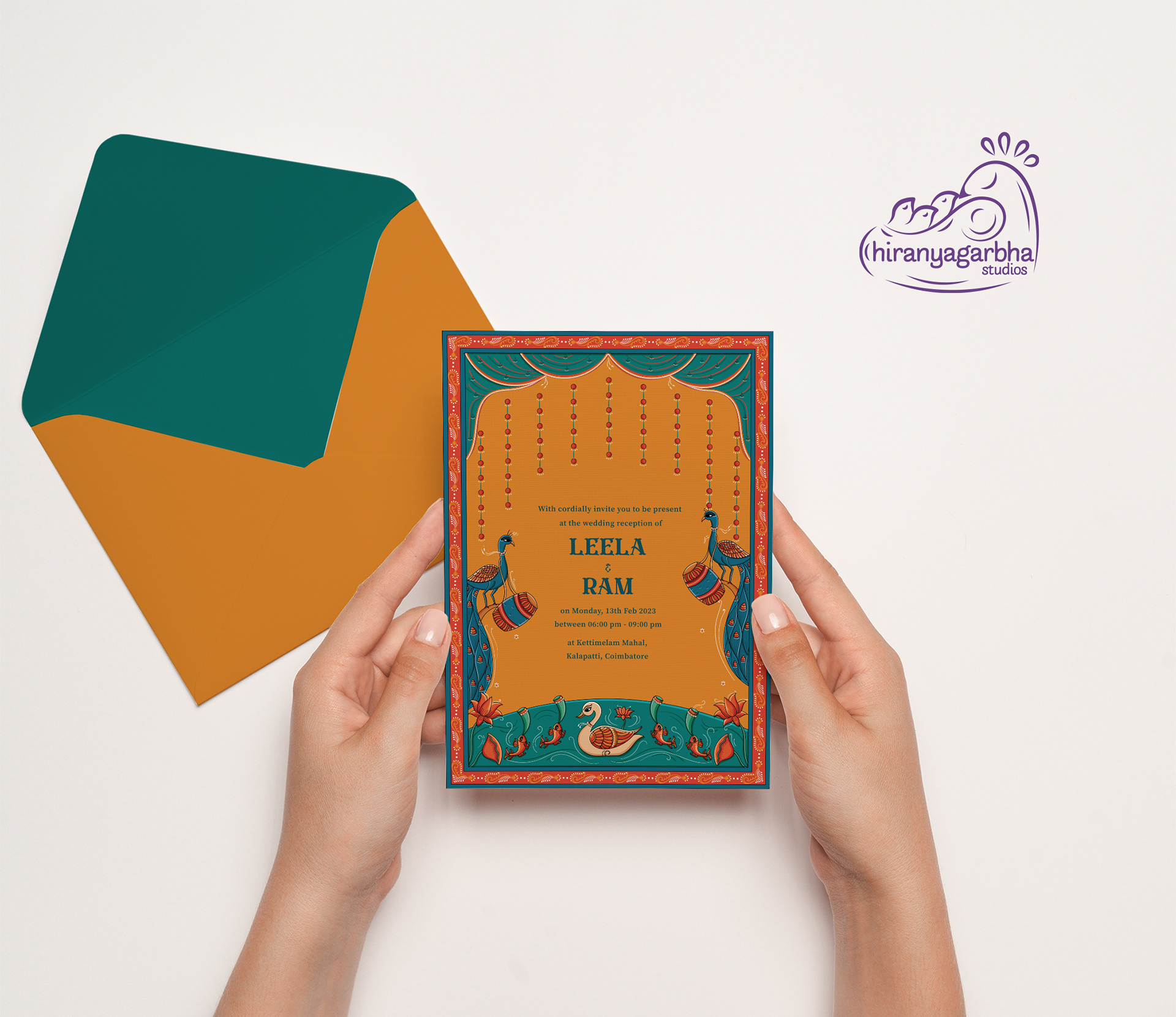 Kettimelam wedding invitation: hands holding the invitation back with a teal envelope