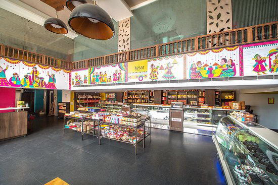 Kesar sweet shop space branding in Phad painting style: sweet shop counters with the illustrated frieze