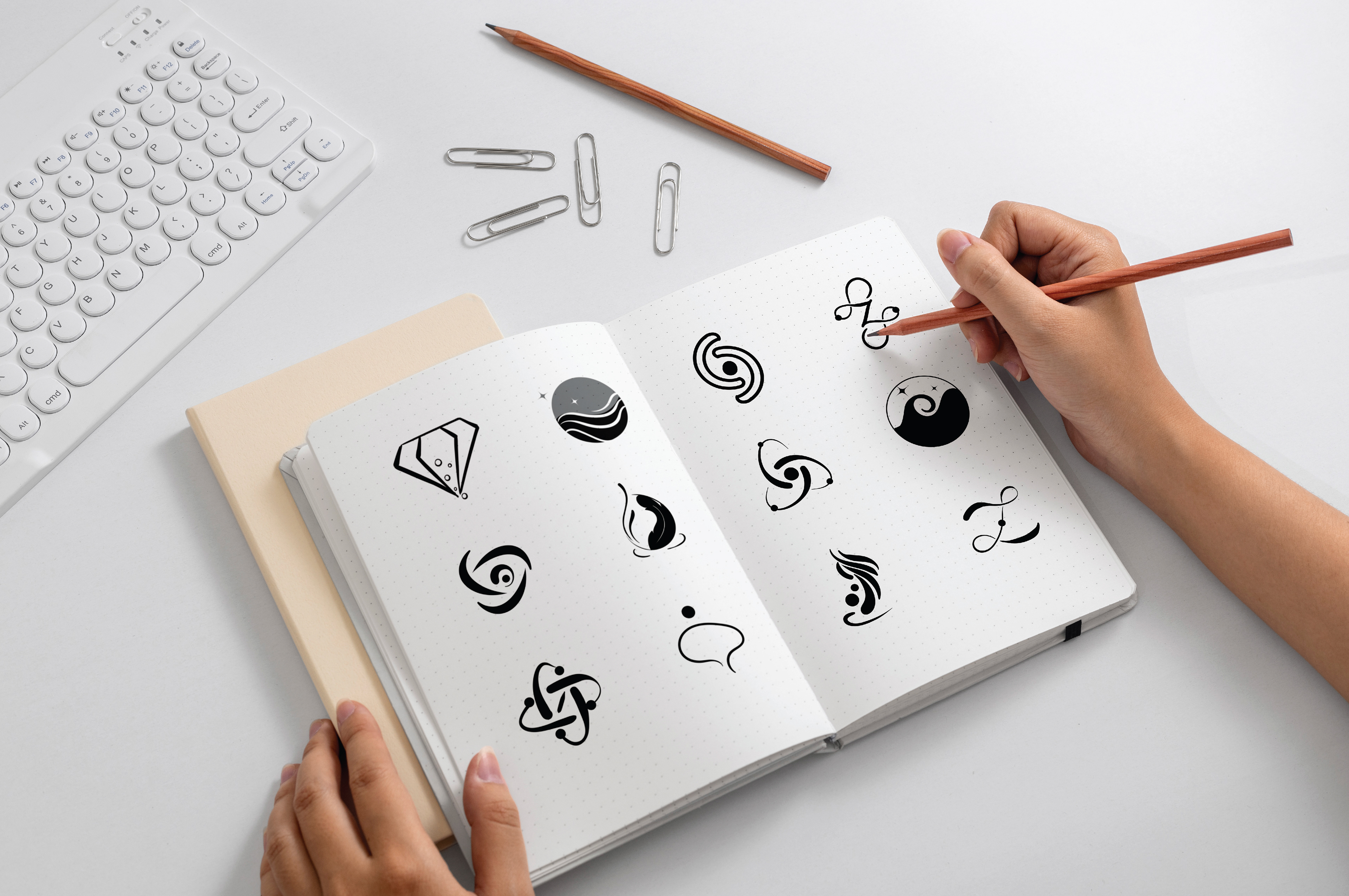 Zyra coconut skincare brand: hand sketching logo ideas in a notebook