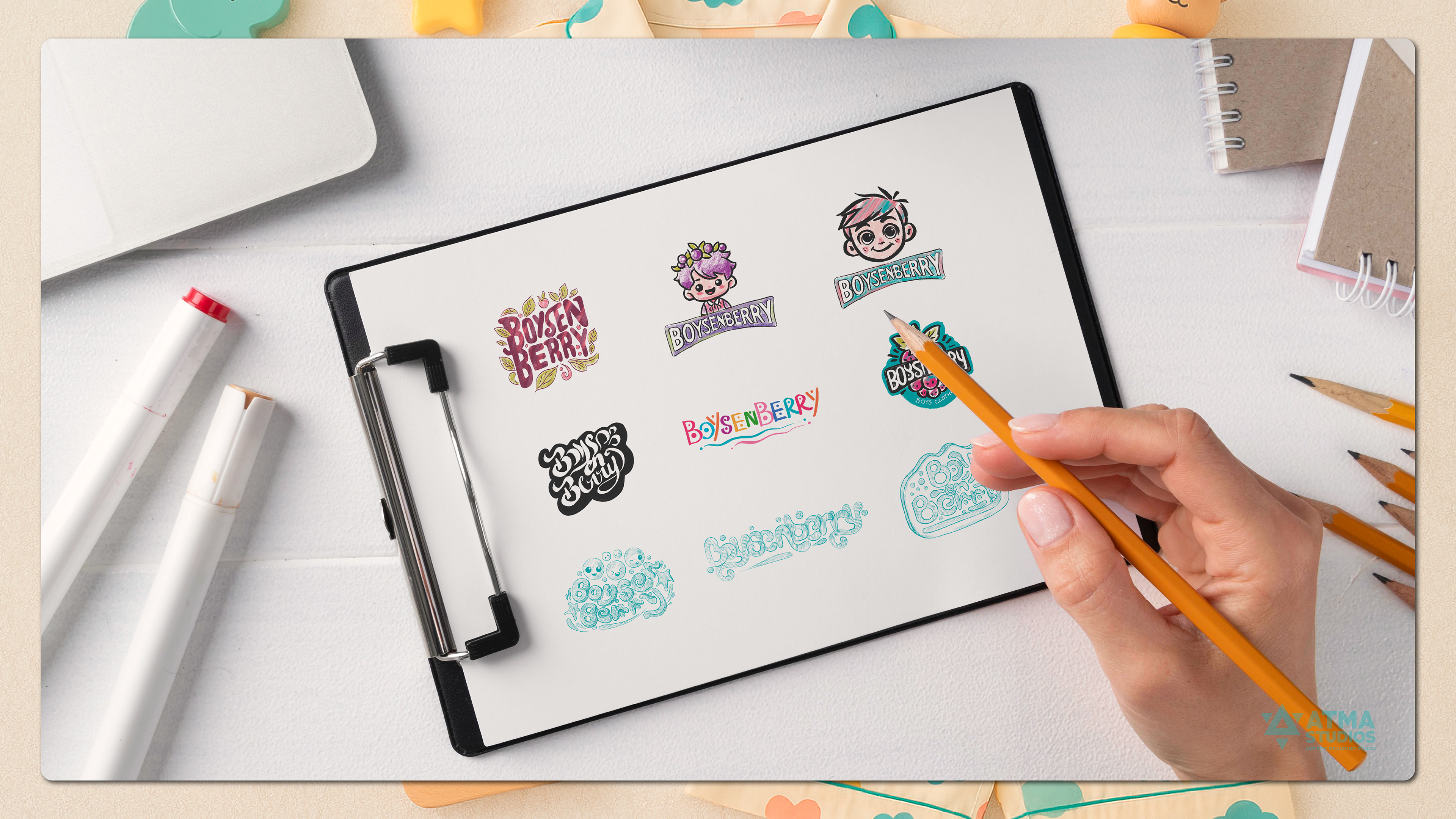 Boysenberry boys clothing brand: hand sketching logo sticker ideas on a clipboard