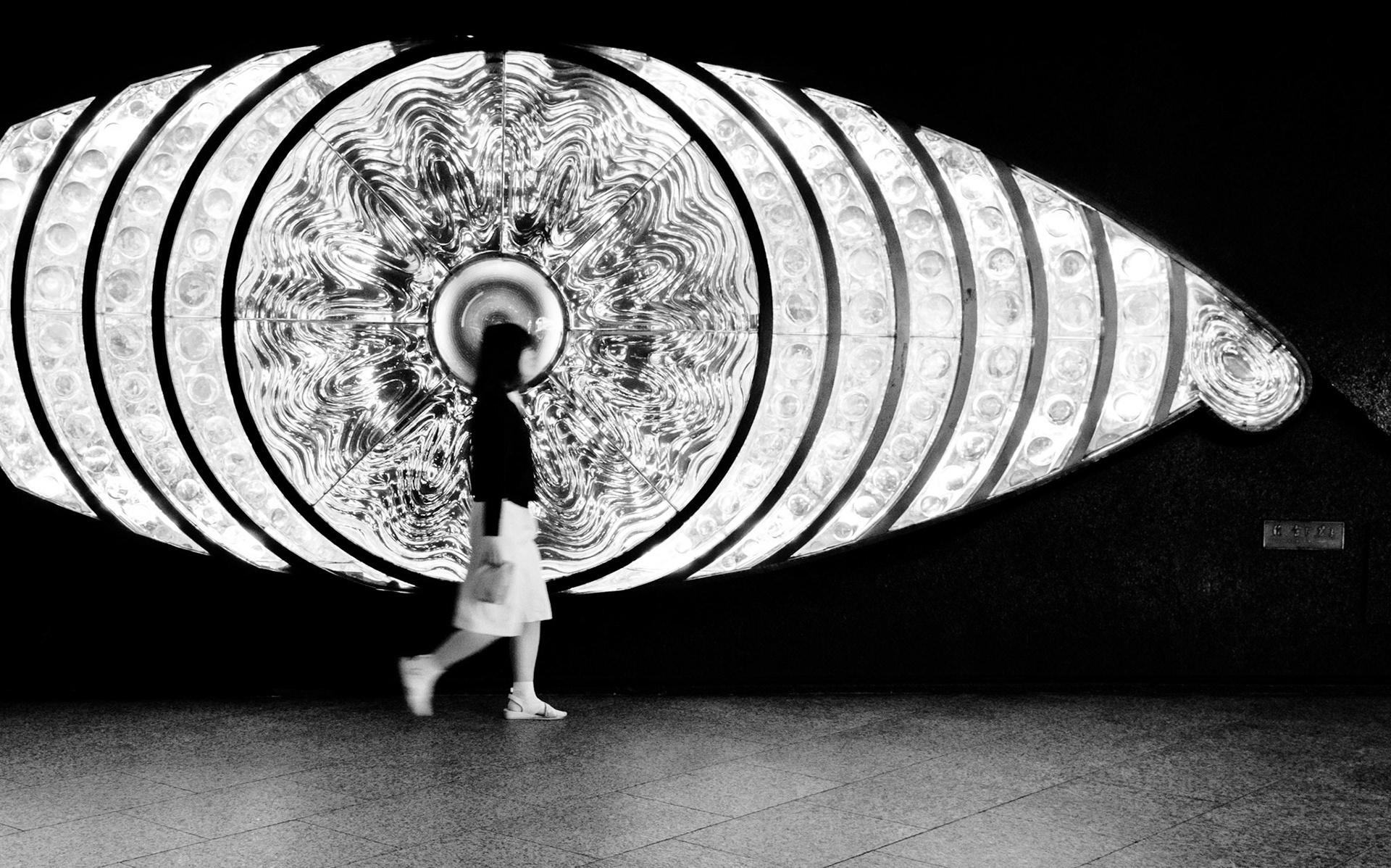 Unidentifiable girl walking past the Eyeball in Shinjuku Station, Tokyo