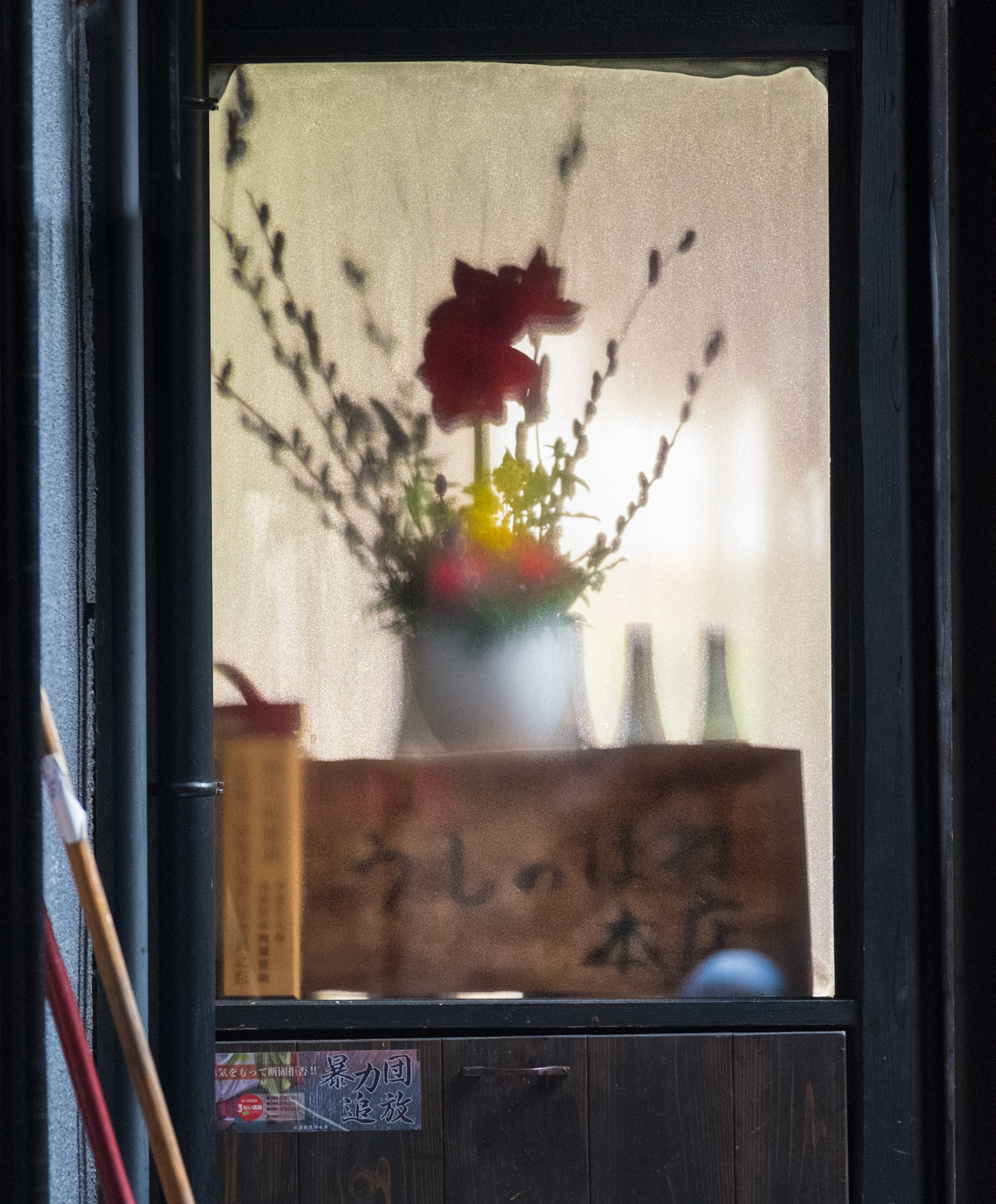 A view of an ikebana flower arrangement seen through a frosty window in Kyoto.