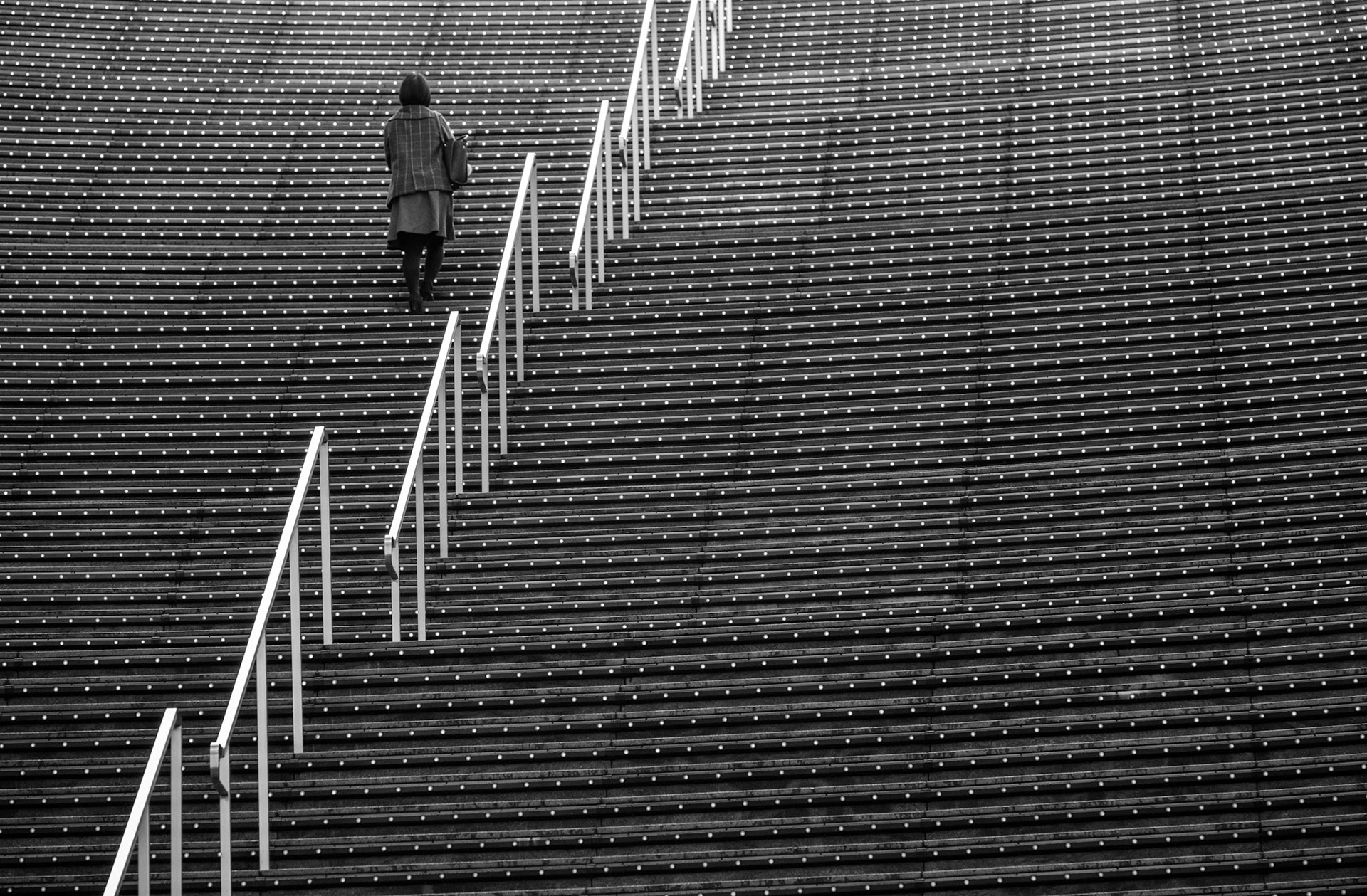 A woman walks up the LED light illuminated stairs inside Kyoto Station.