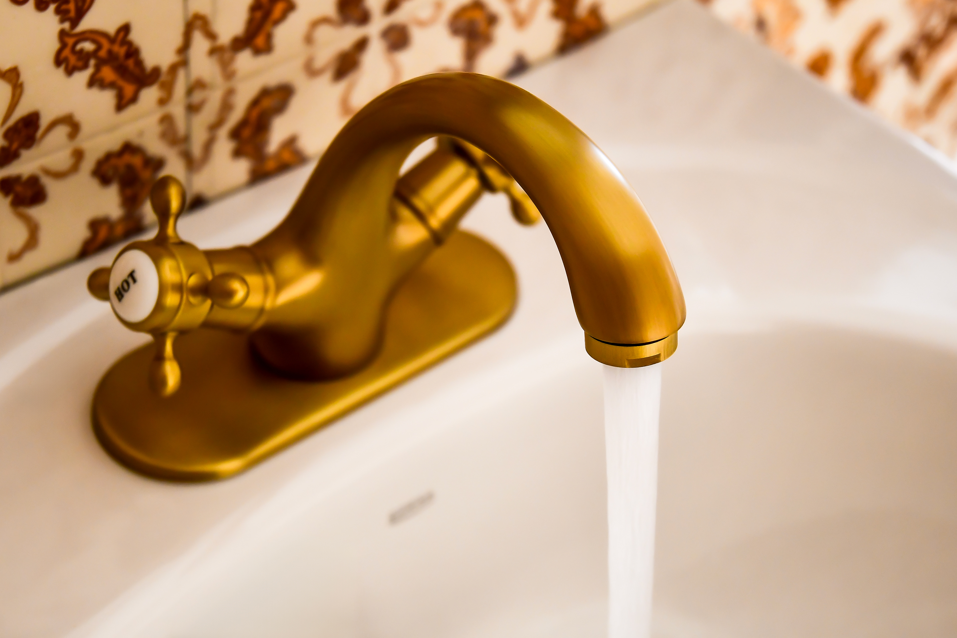 A close-up of a modern bathroom sink faucet in the master suite of Hacienda Eterna Primavera, blending new fixtures with restored charm.