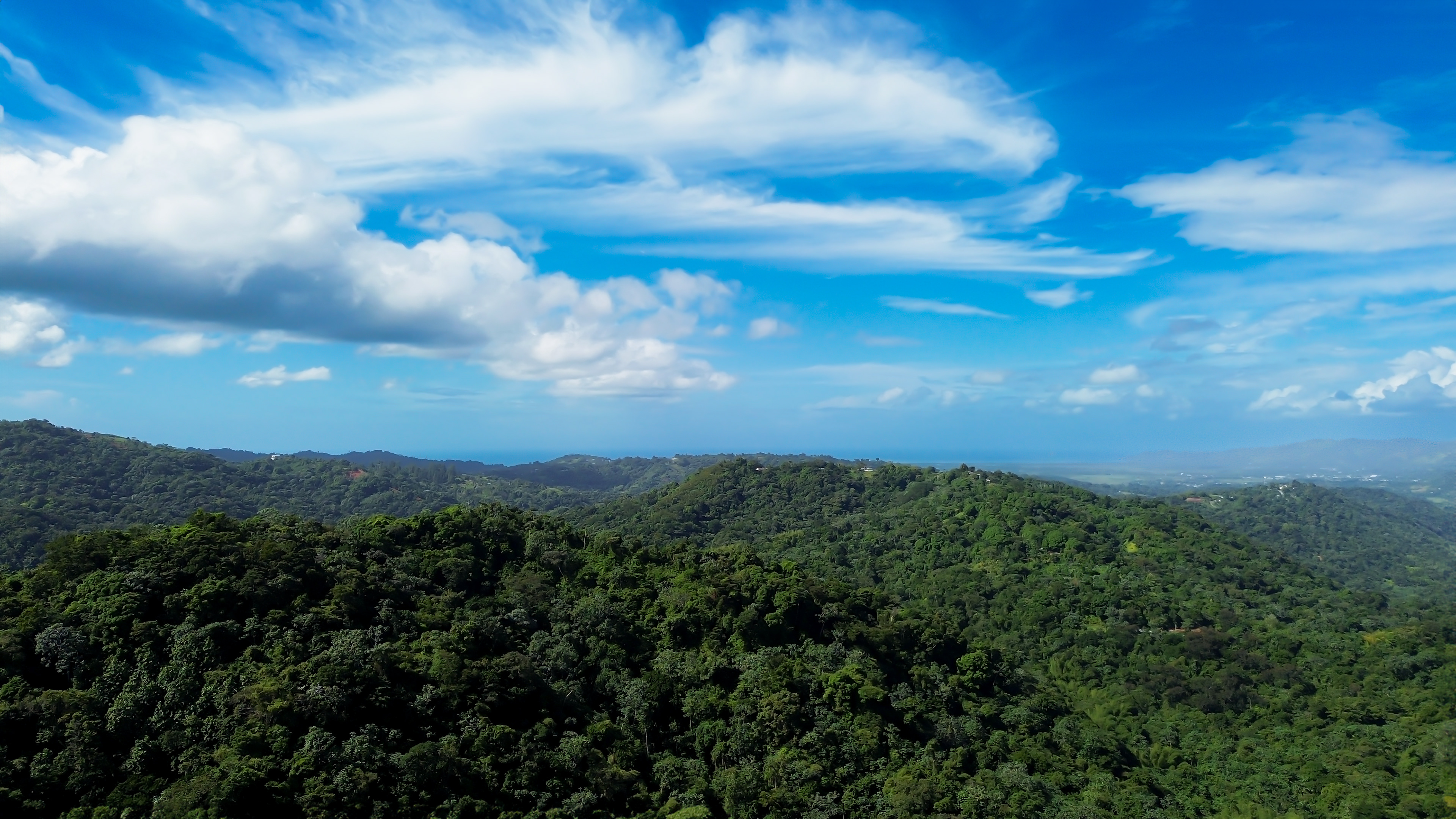 Stunning drone view of the mountains in Puerto Rico leading to the beach, showcasing the natural beauty of the landscape and breathtaking coastal views.