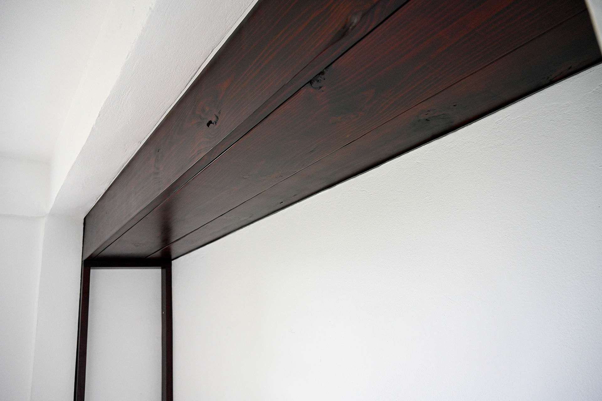 Dark wood shelves installed in the master suite at Hacienda Eterna Primavera, showcasing natural materials and cozy, handcrafted design.