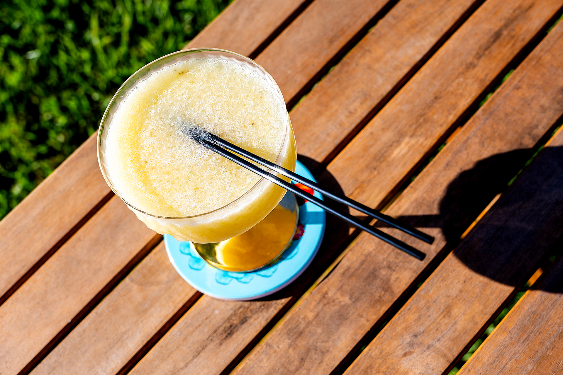 A freshly made banana daiquiri sits in the lush tropical garden of Hacienda Eterna Primavera, offering a refreshing taste of paradise in Puerto Rico.