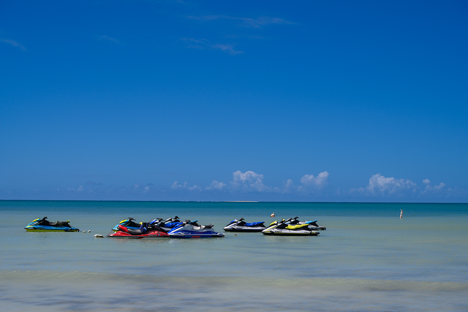 Jet skis lined up along the edge of Playa Santa Beach, ready for visitors to explore the crystal-clear waters of the Caribbean. The stunning blue ocean offers the perfect setting for water sports and adventure in Puerto Rico.