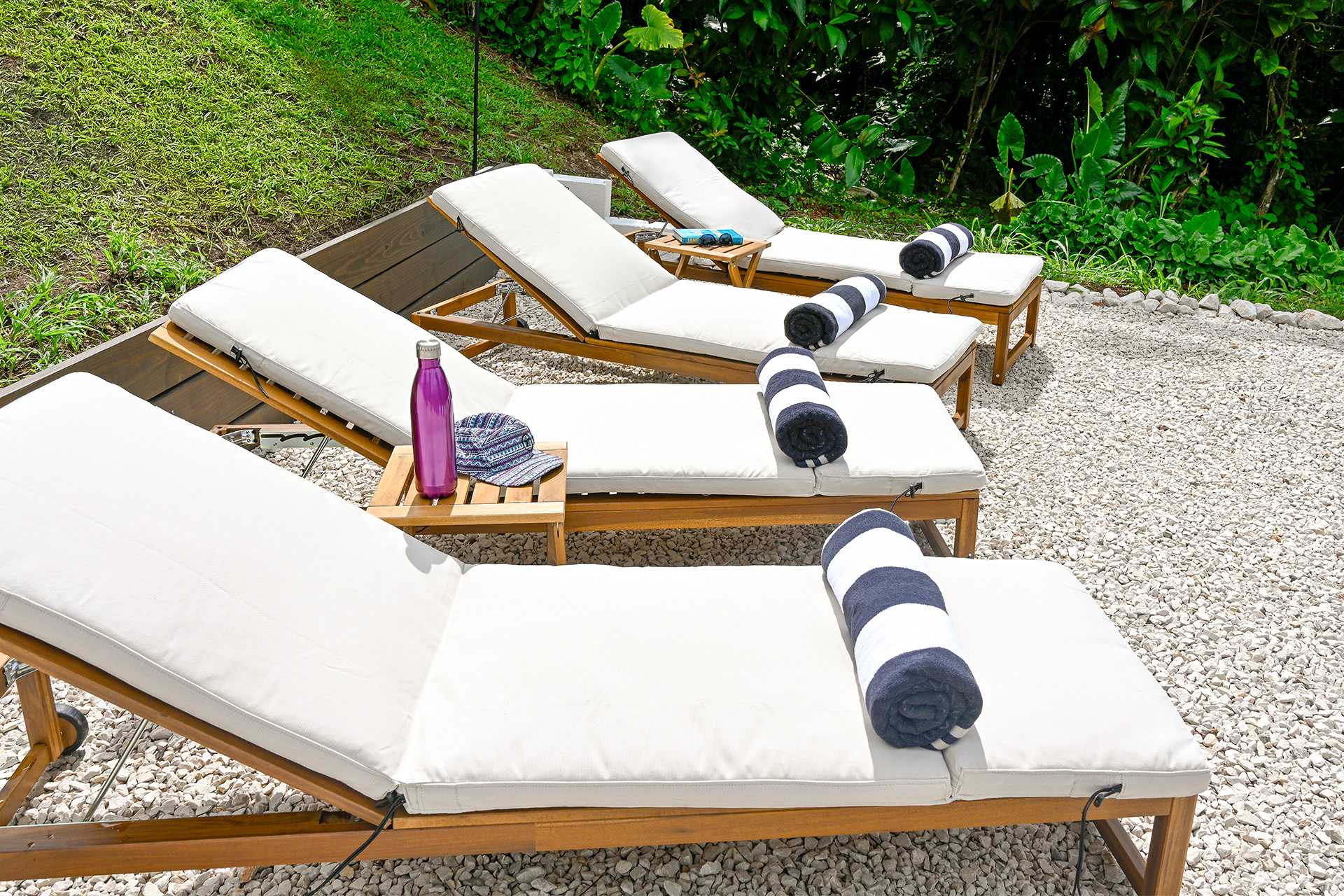 Sun lounge chairs arranged in a private tropical garden with lush greenery at Hacienda Eterna Primavera.