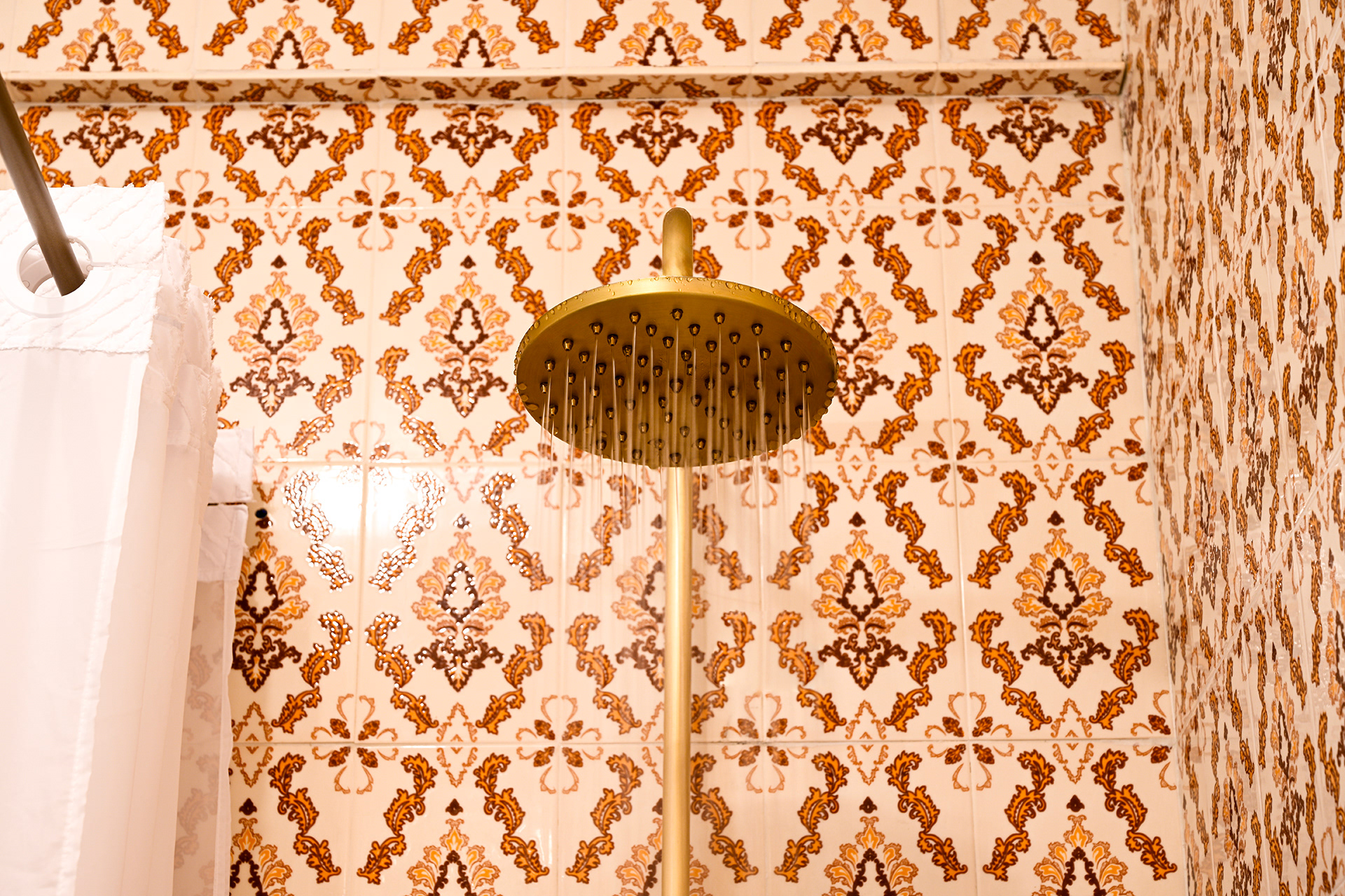 Modern rainfall shower head with vintage hacienda tile background at Hacienda Eterna Primavera.