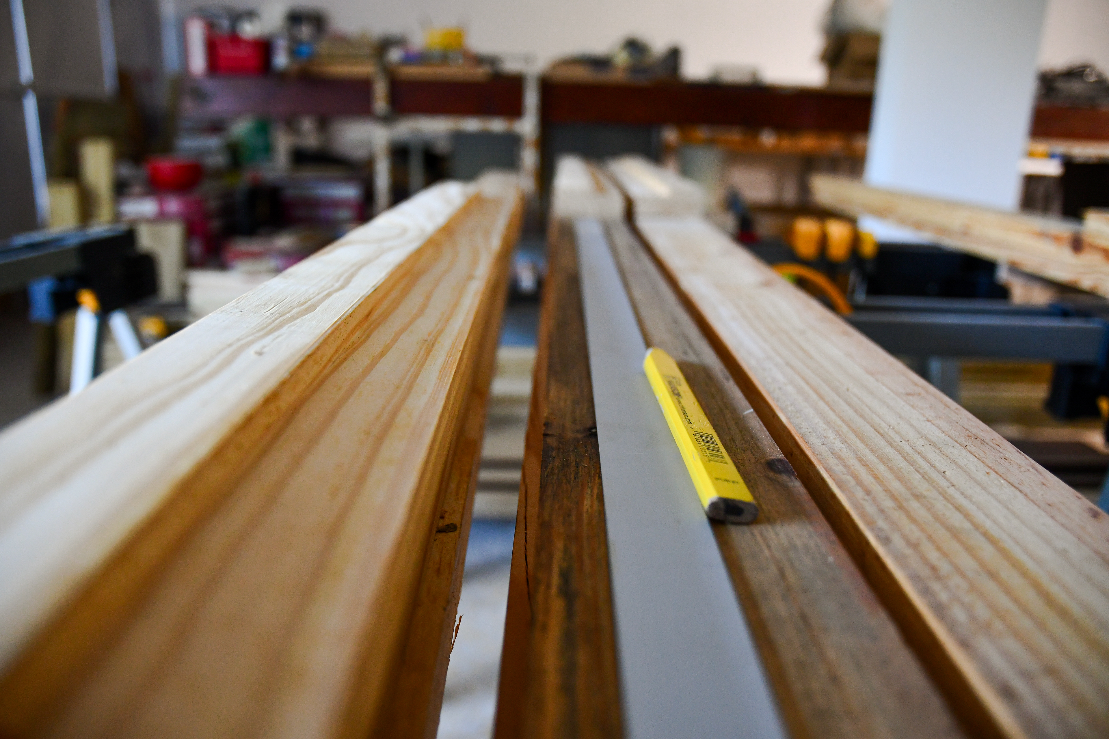 Stacks of raw wood ready for cutting and sanding to create handcrafted shelves and wooden doors for the cozy kitchen at Hacienda Eterna Primavera