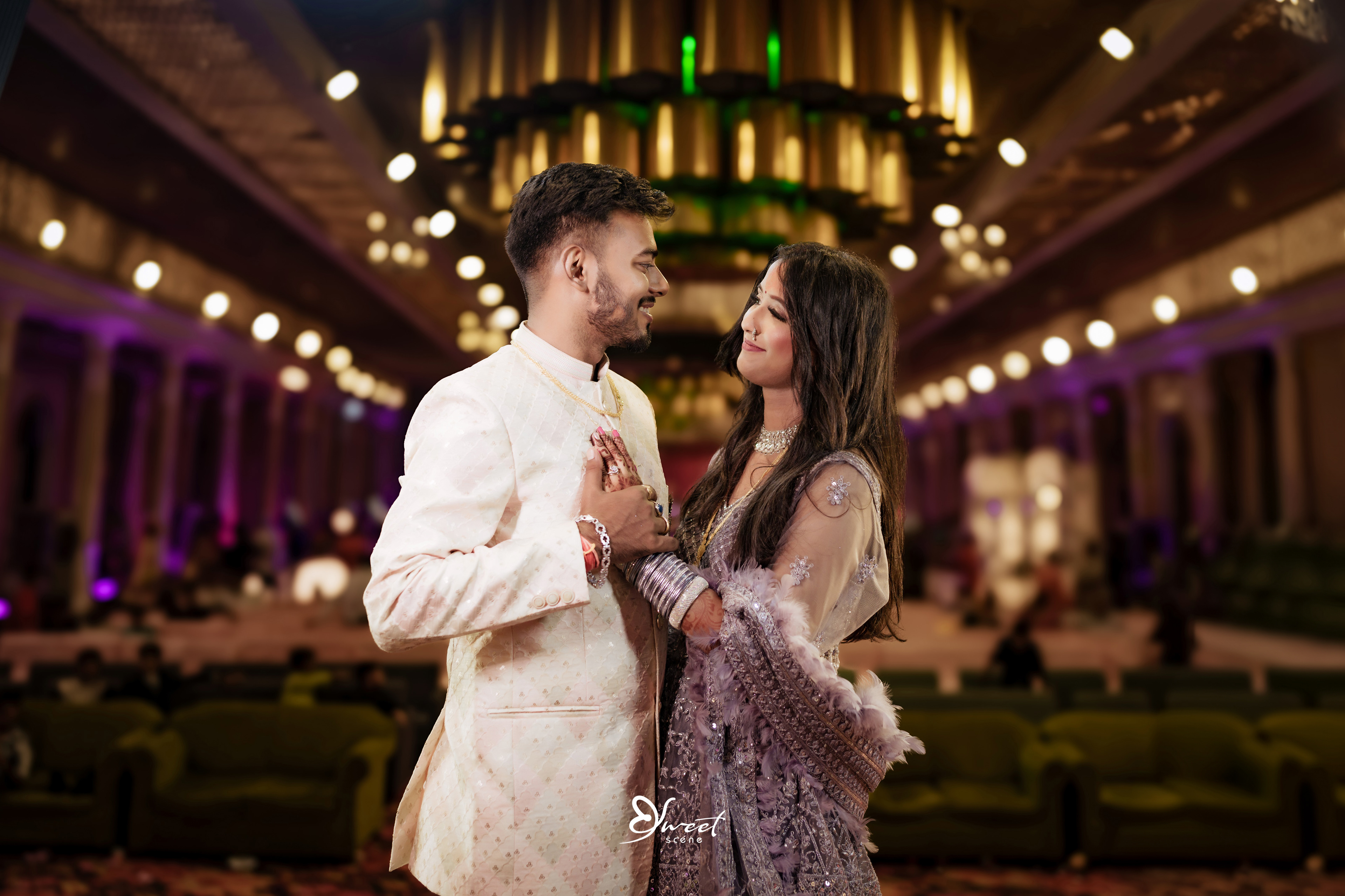 The couple exchanging rings with tender smiles, surrounded by their family and friends.