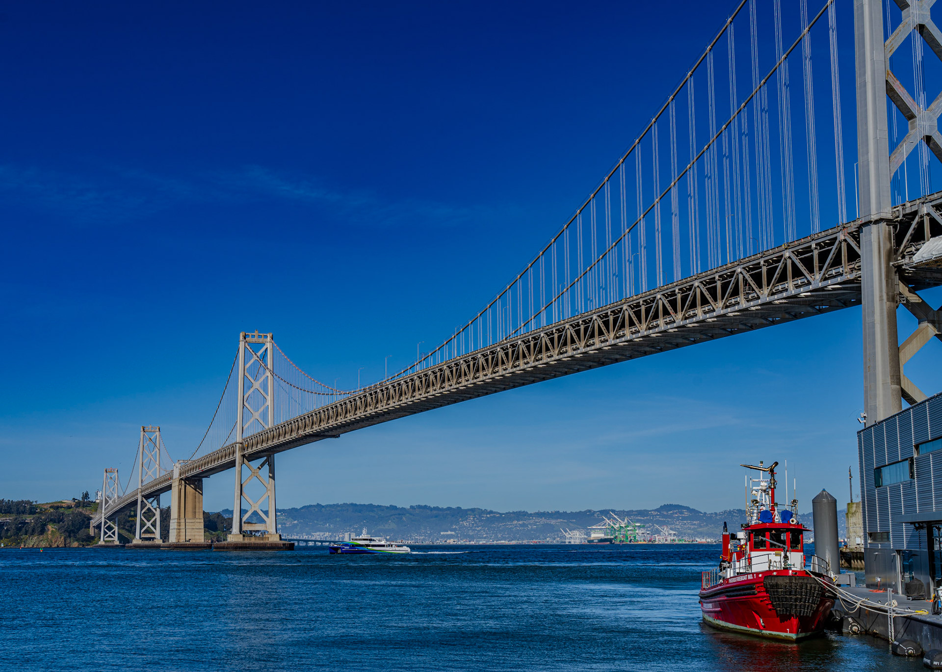 A ferry crosses under the Bay Bridge