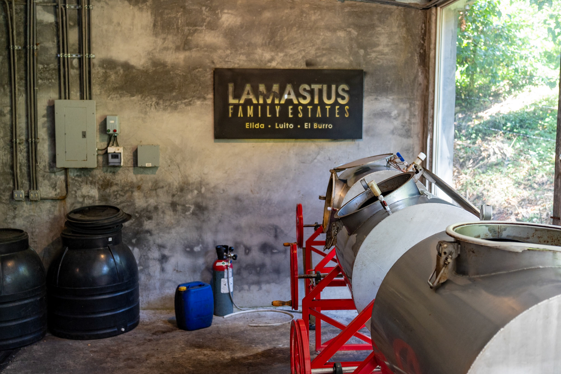 JM Estrada 200 liter rotary fermenters in the Anaerobic Slow Dry (ASD) vault of Lamastus Elida Estate. Inert gas container from Café Don Benjie on the ground with liquor run off in the blue container.