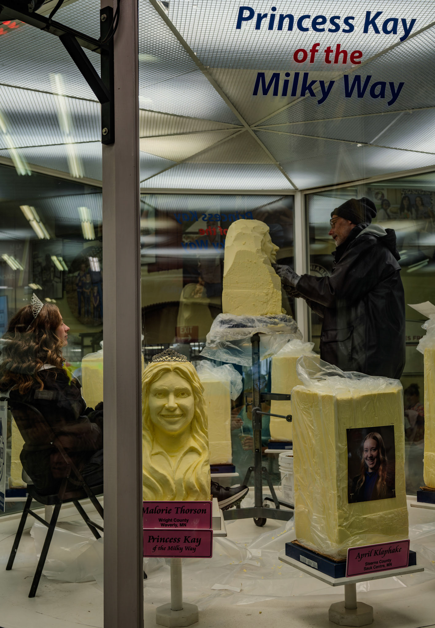 Alexis Hoefs of New Prague poses for her butter sculpture as runner up in the Minnesota State Fair's Princess Kay of the Milky Way competition. Winner Malorie Thorson's carved butter sculpture sits next to her, with other blocks of butter in the cold room designated for other contestants.