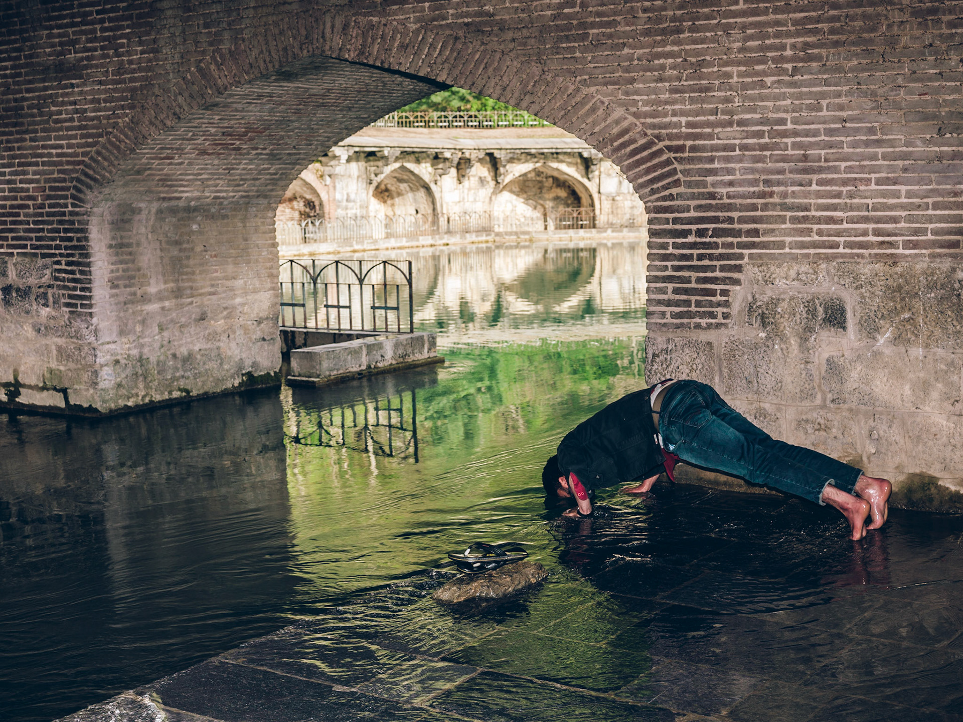 A man tastes fresh water from the Verinag Spring - source of the Jhelum River. Kashmir, 2019.