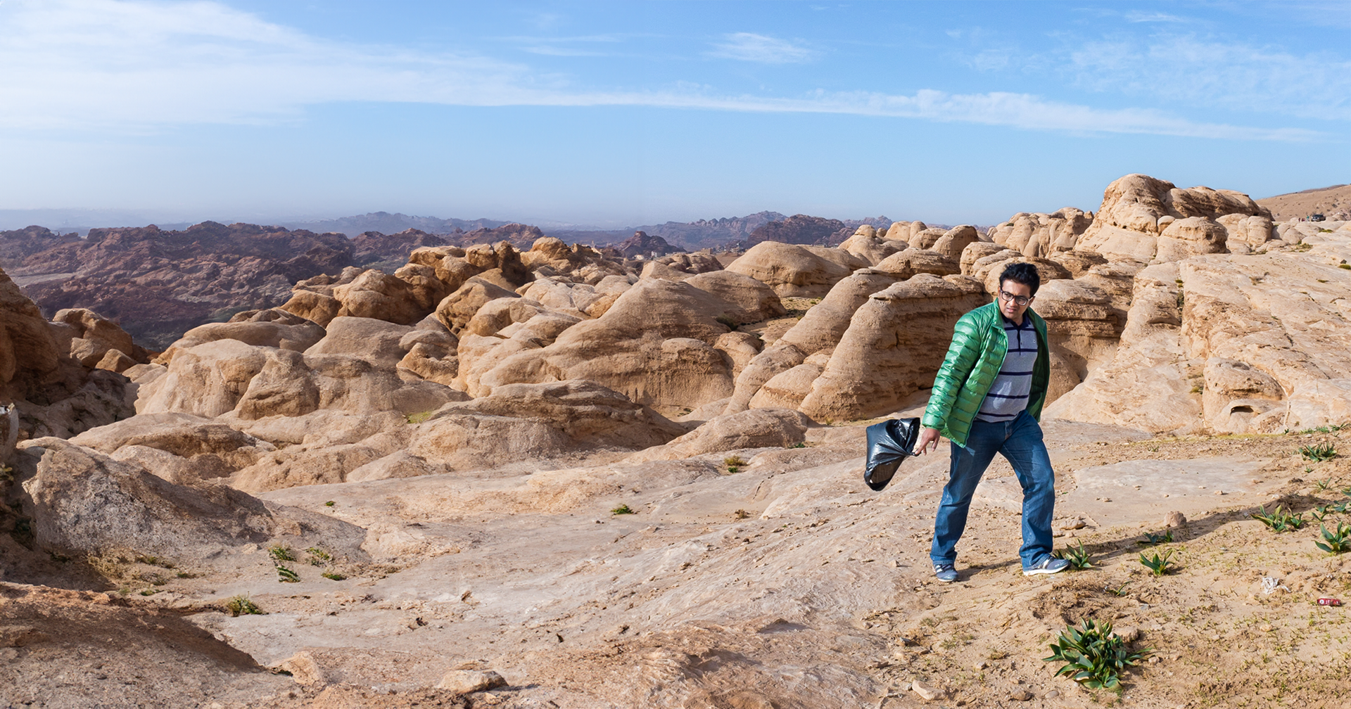 Mahesh Shantaram picking litter in the hills surrounding the Petra archeological site in Jordan