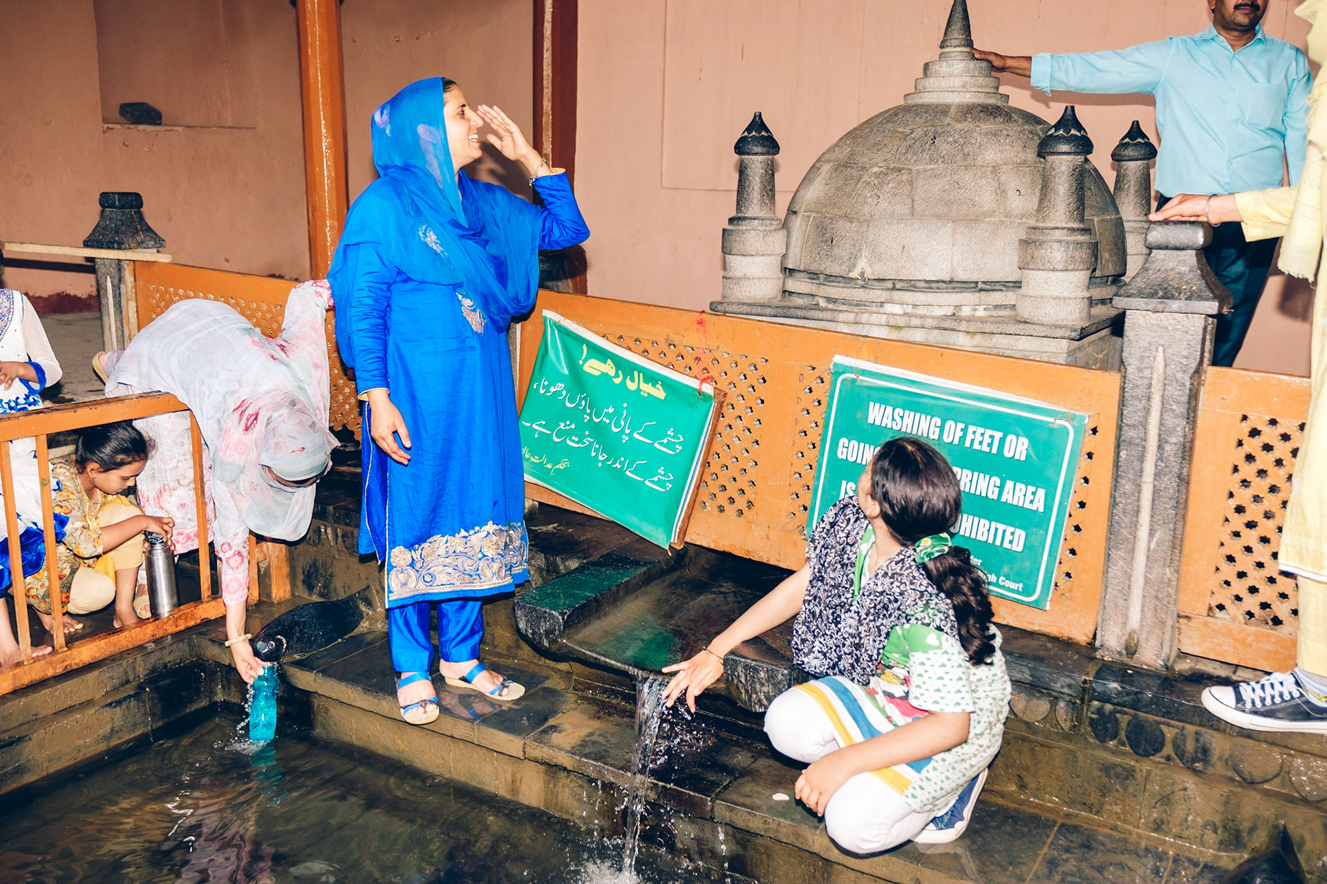 Visitors to the spring fountain at Chashme Shahi gardens. Srinagar, Kashmir, 2019.