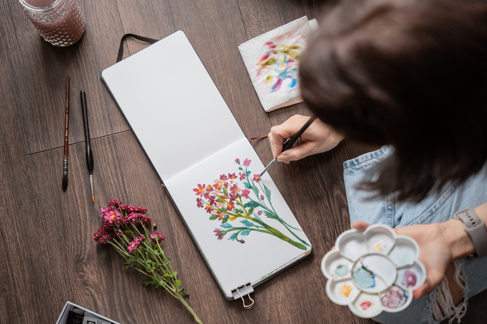 Illustratore Dace Krēsliņa zīmē ar guaša krāsām bordo krāsas ziedus