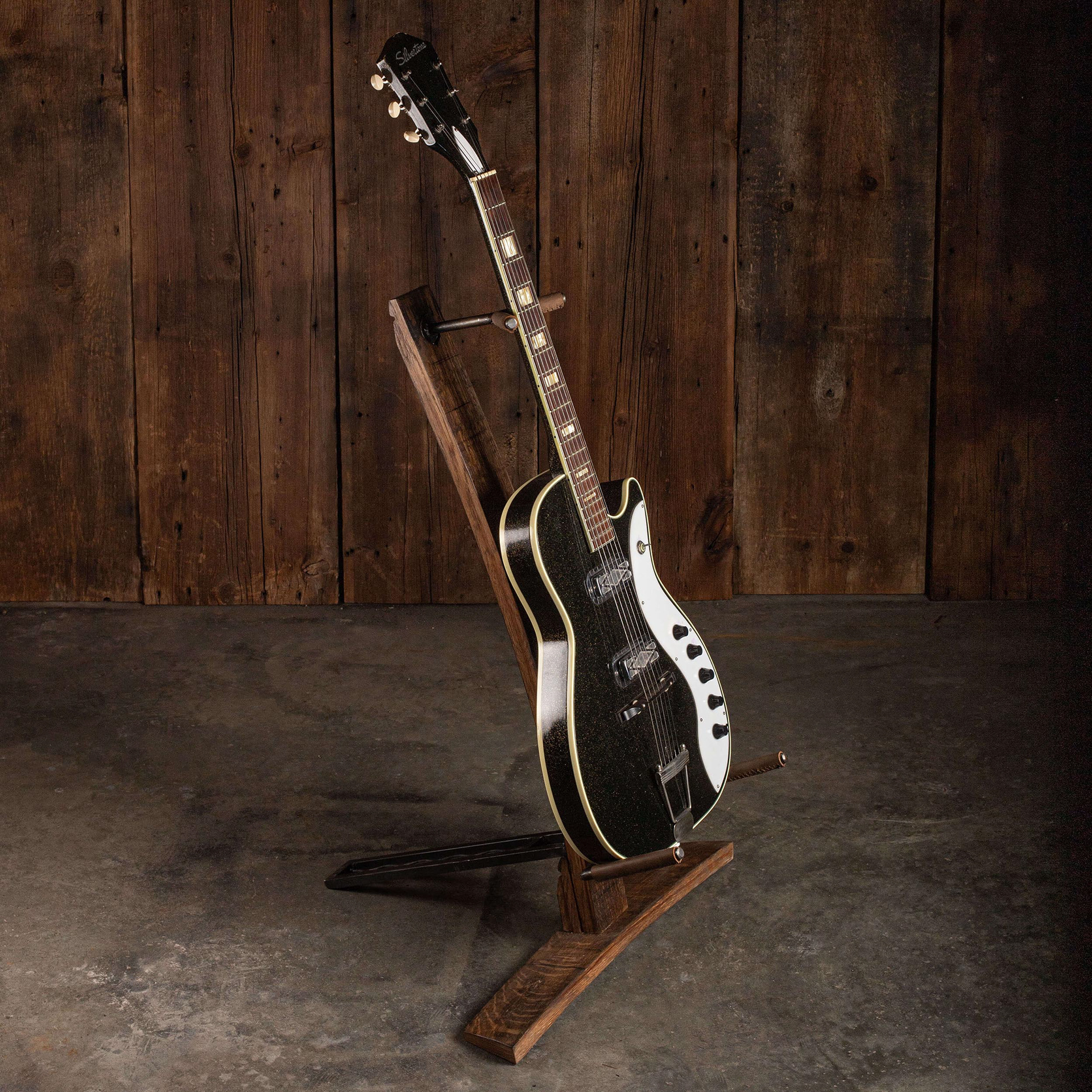 guitar sitting on a whiskey barrel guitar stand
